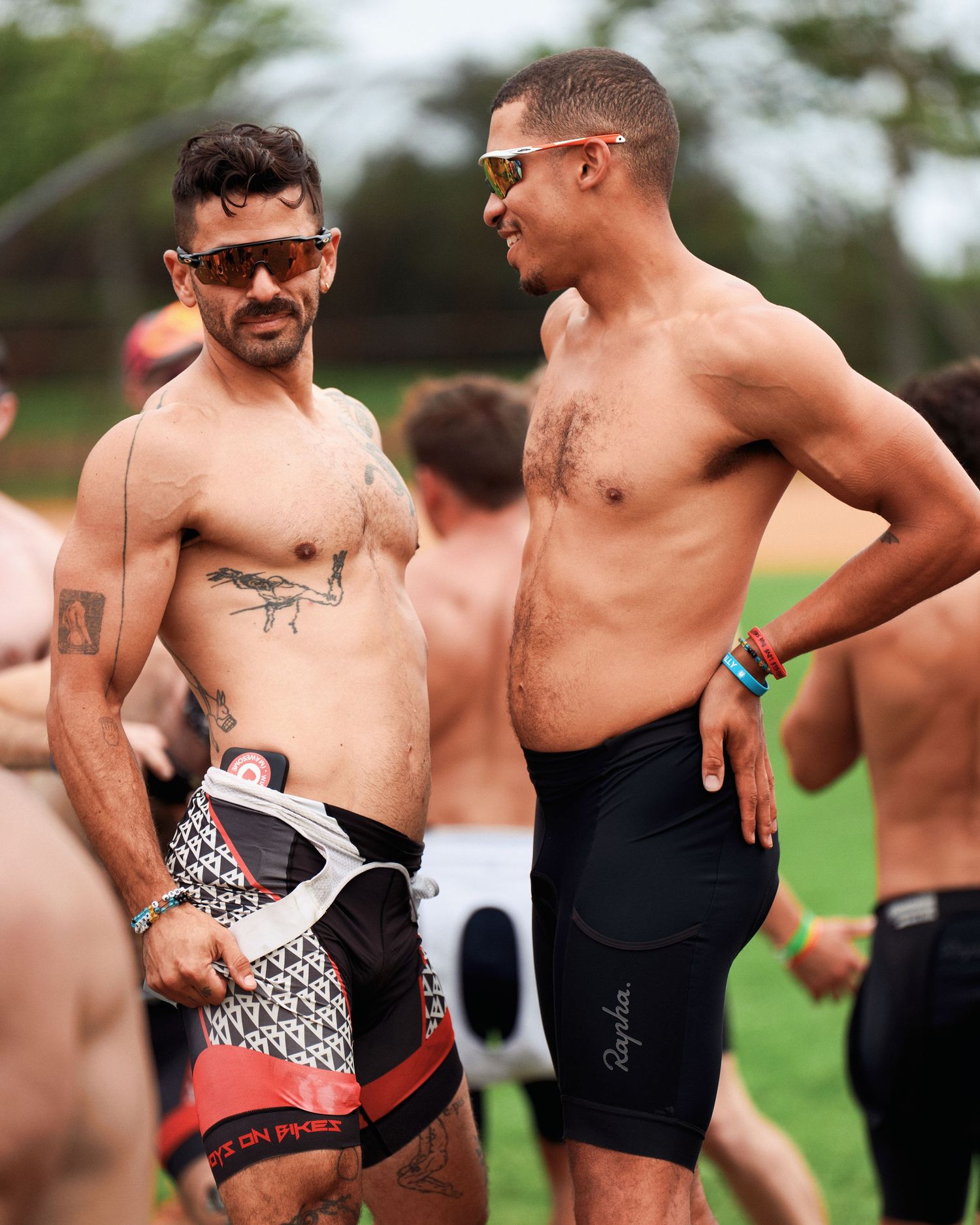Athletic participants gathered outdoors wearing sportswear and chatting between events.