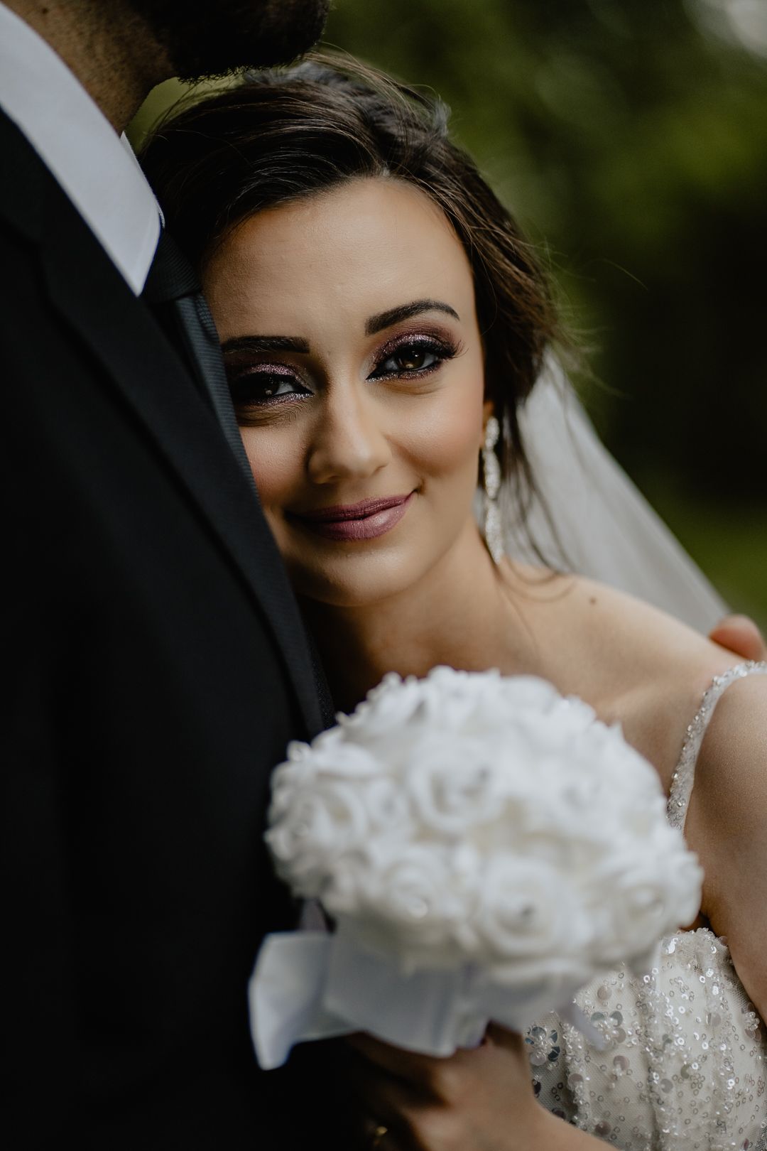 a wedding portrait shot of a bride lening on her man's chest with a flower