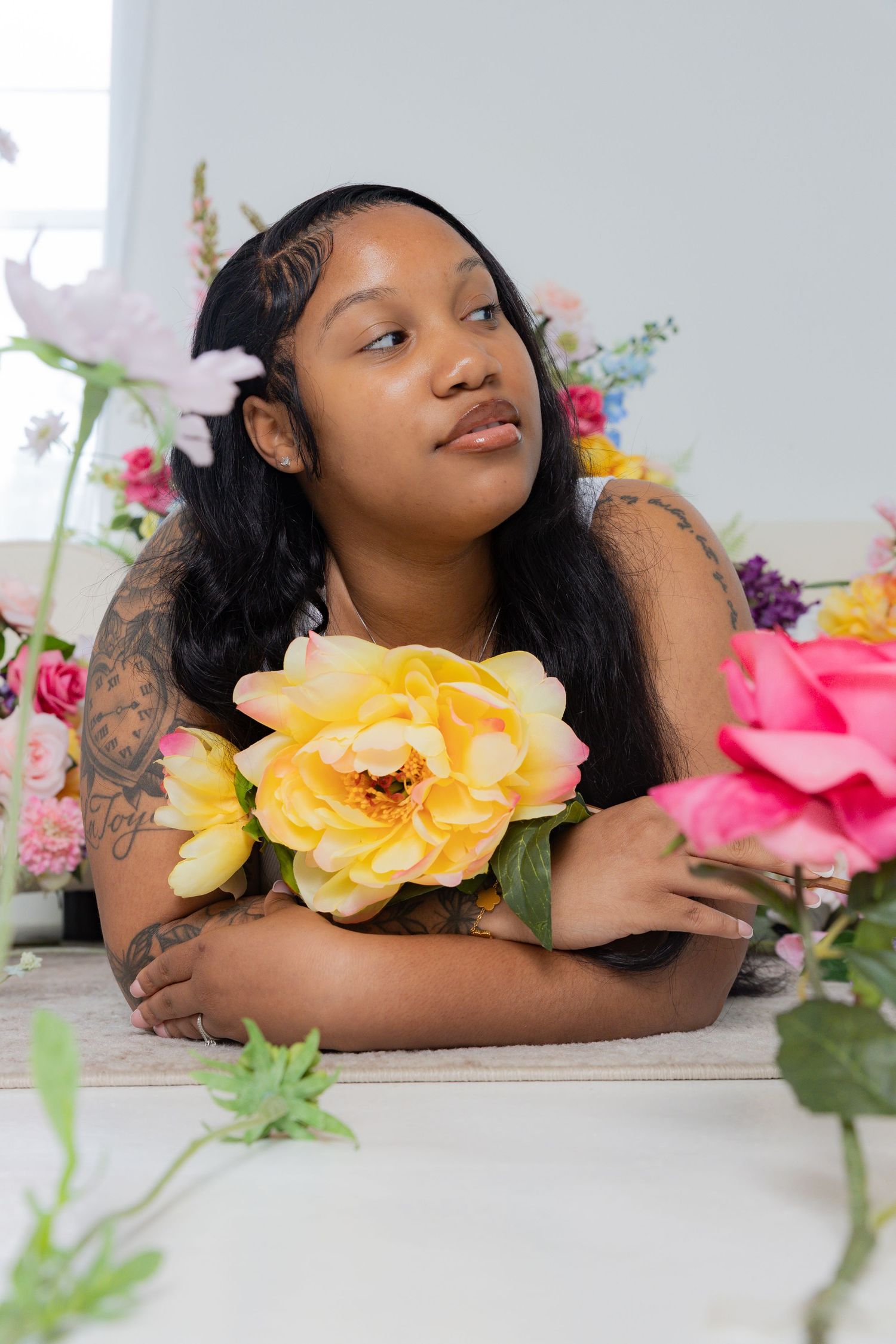 Artistic portrait with yellow roses and colorful floral arrangements against white background.