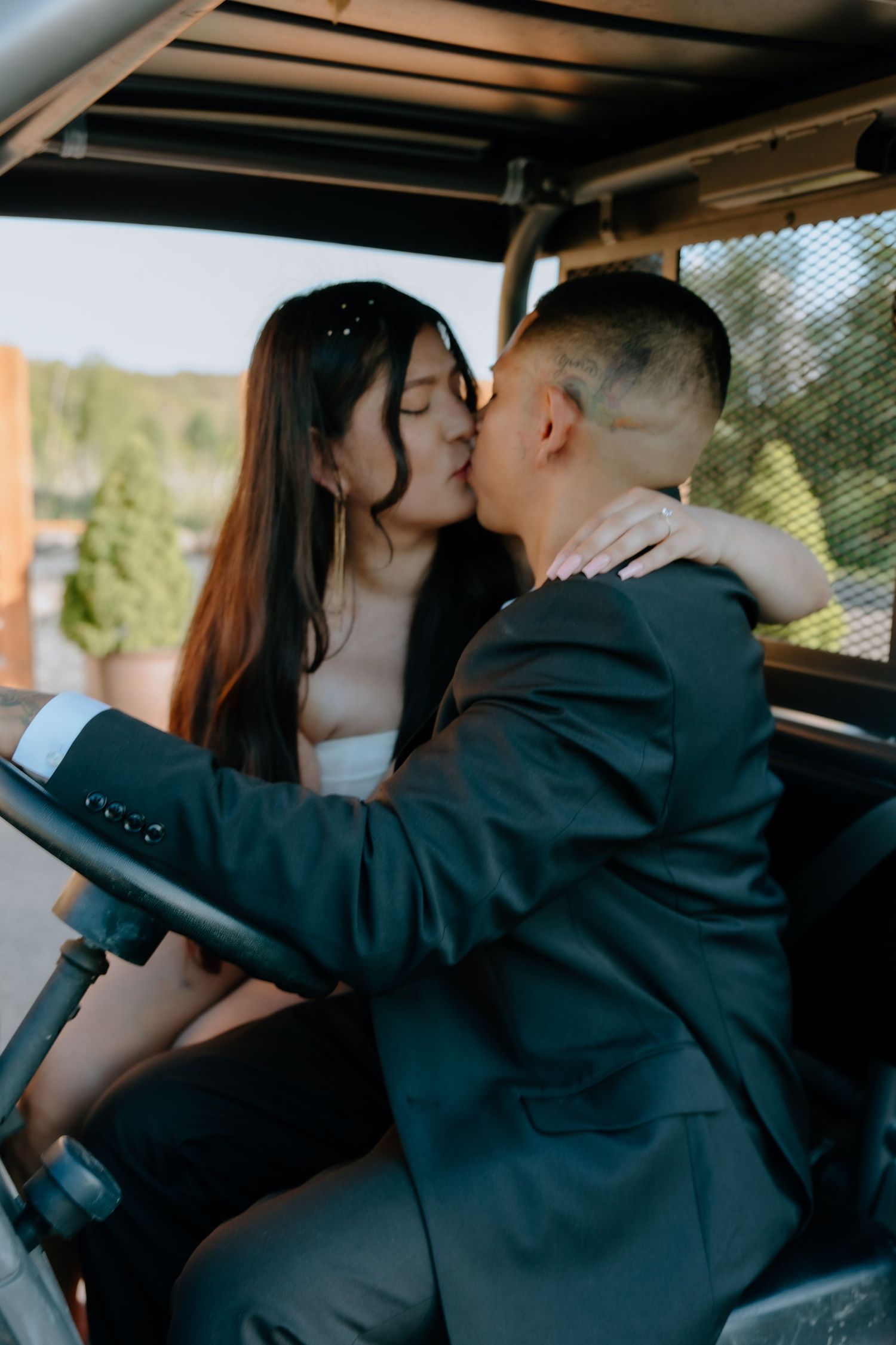 A man and woman embracing each other in a kiss while sitting in a golf cart. Shot at The Barn at Twiggys in Middletown, New York.
