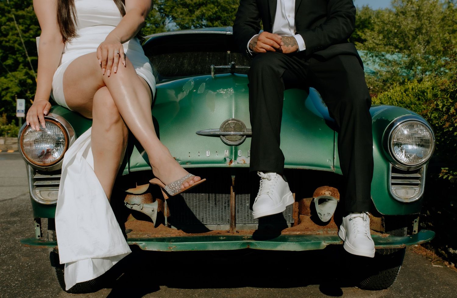A man and woman sit on hood of a vintage car. Shot at The Barn at Twiggys in Middletown, New York.