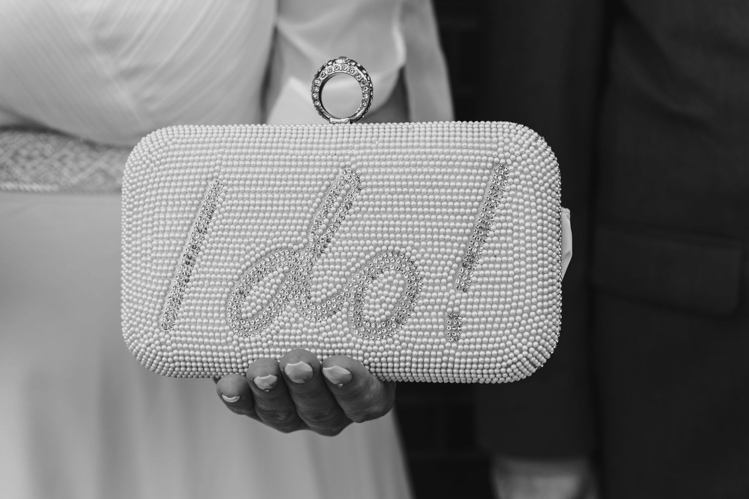 Black and white close-up shots of hands holding a decorative clutch purse. Shot at Poughkeepsie City Hall.