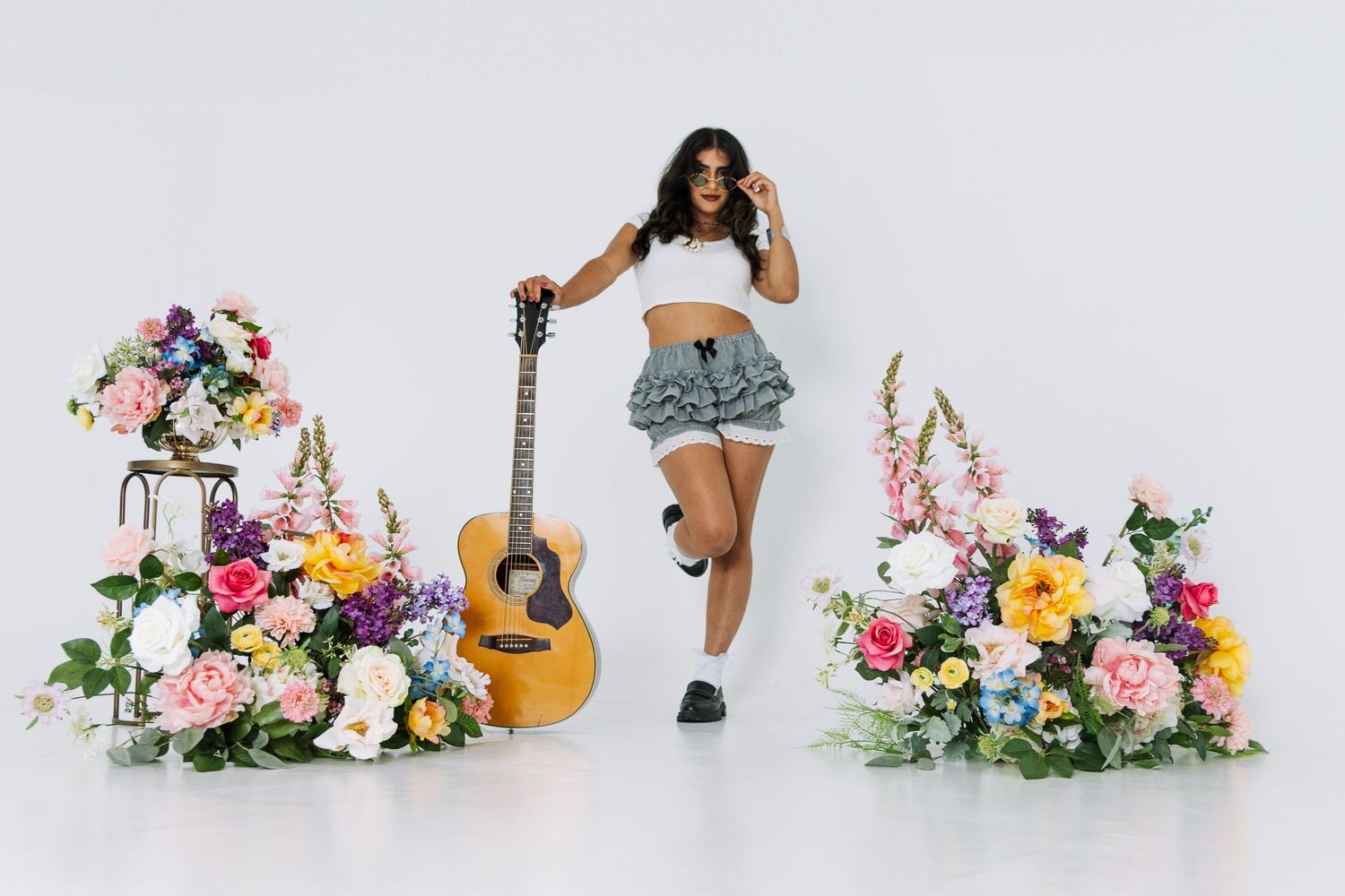 Artistic portrait series with guitar and floral arrangements in studio setting.