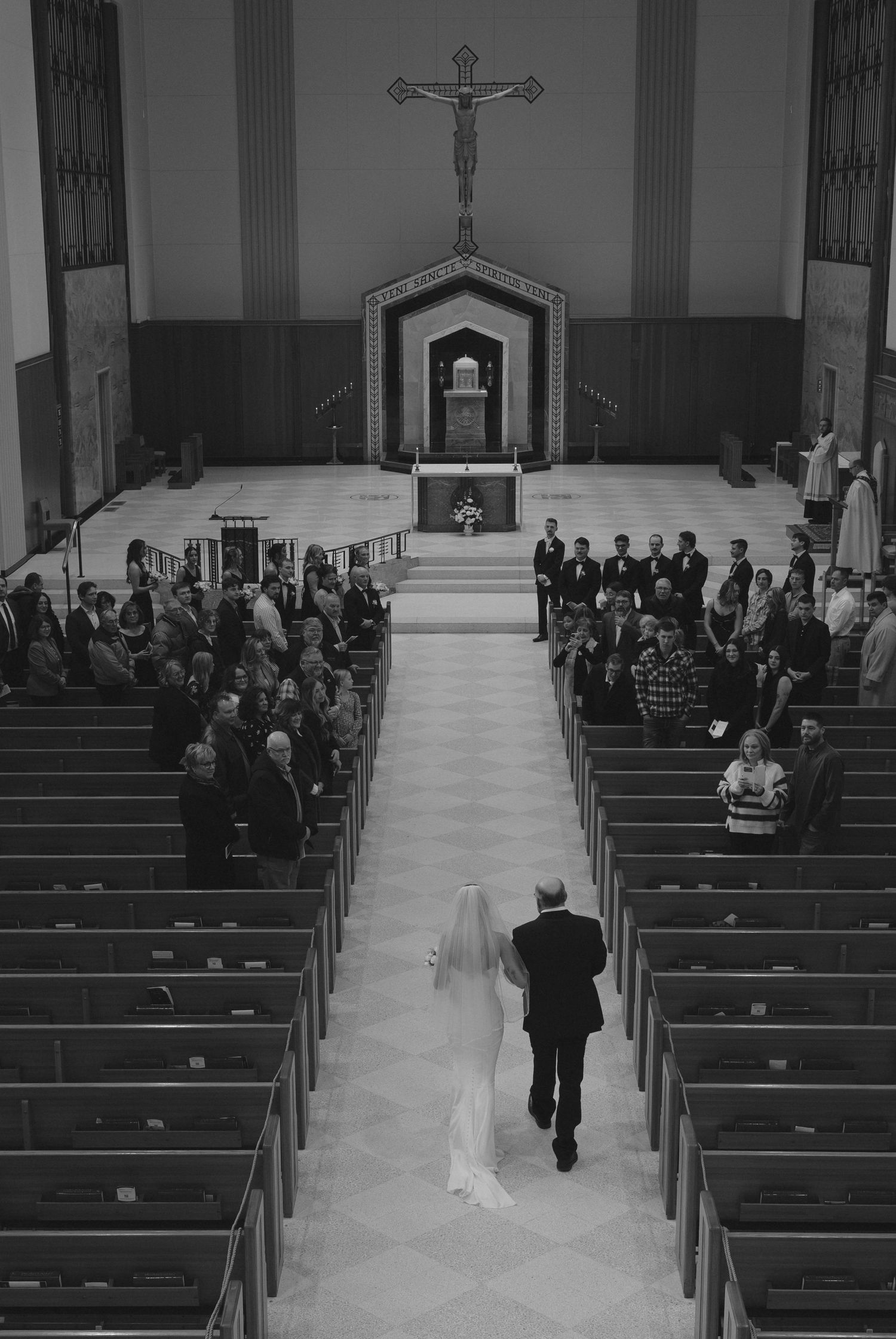 Wedding ceremony in a traditional church with guests seated in wooden pews.