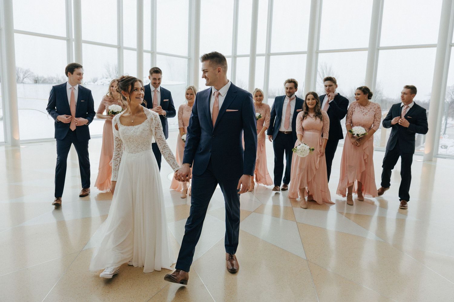 Panoramic view of a modern wedding venue with guests mingling in formal attire.
