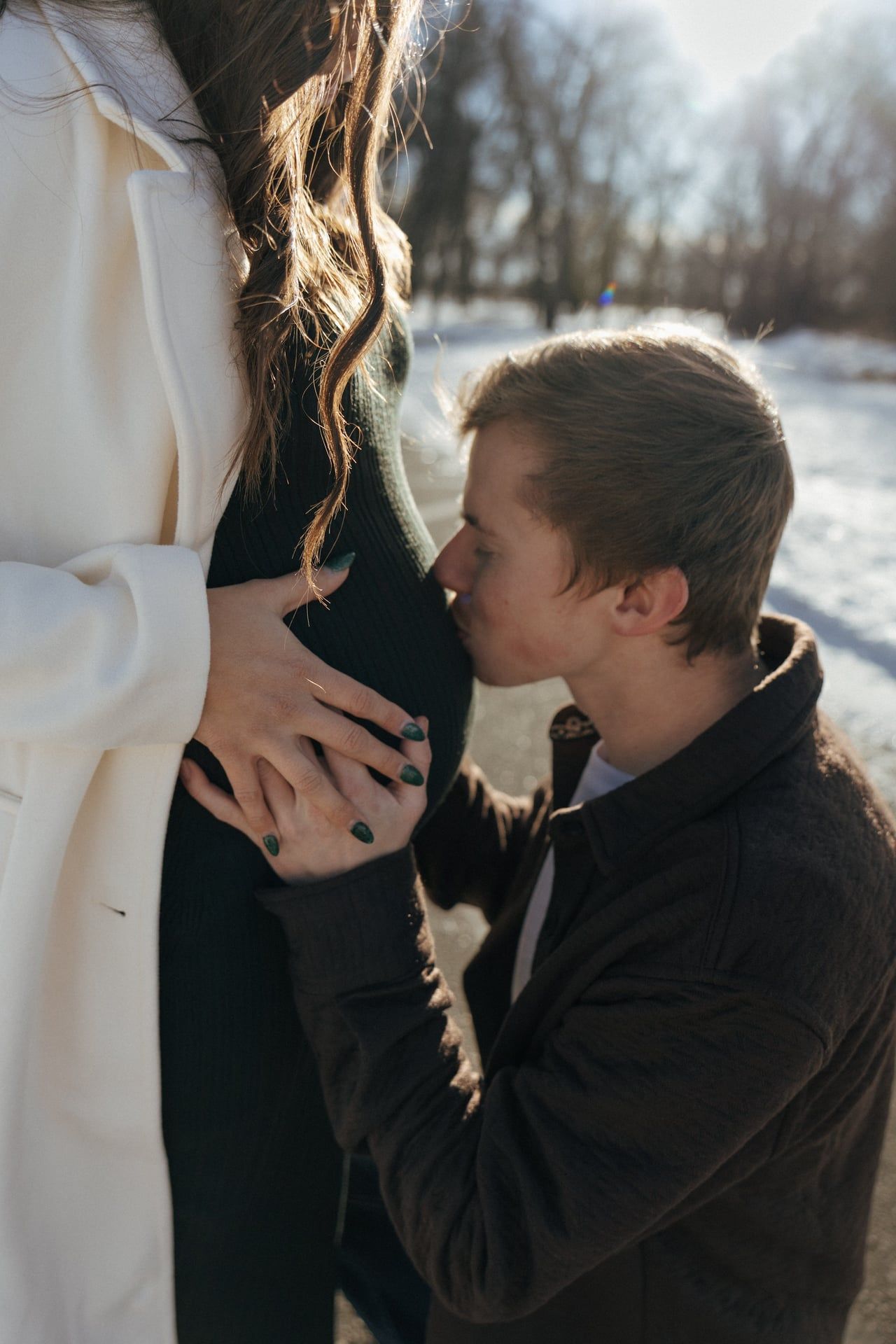 man kissing belly bump for maternity session in Bismarck