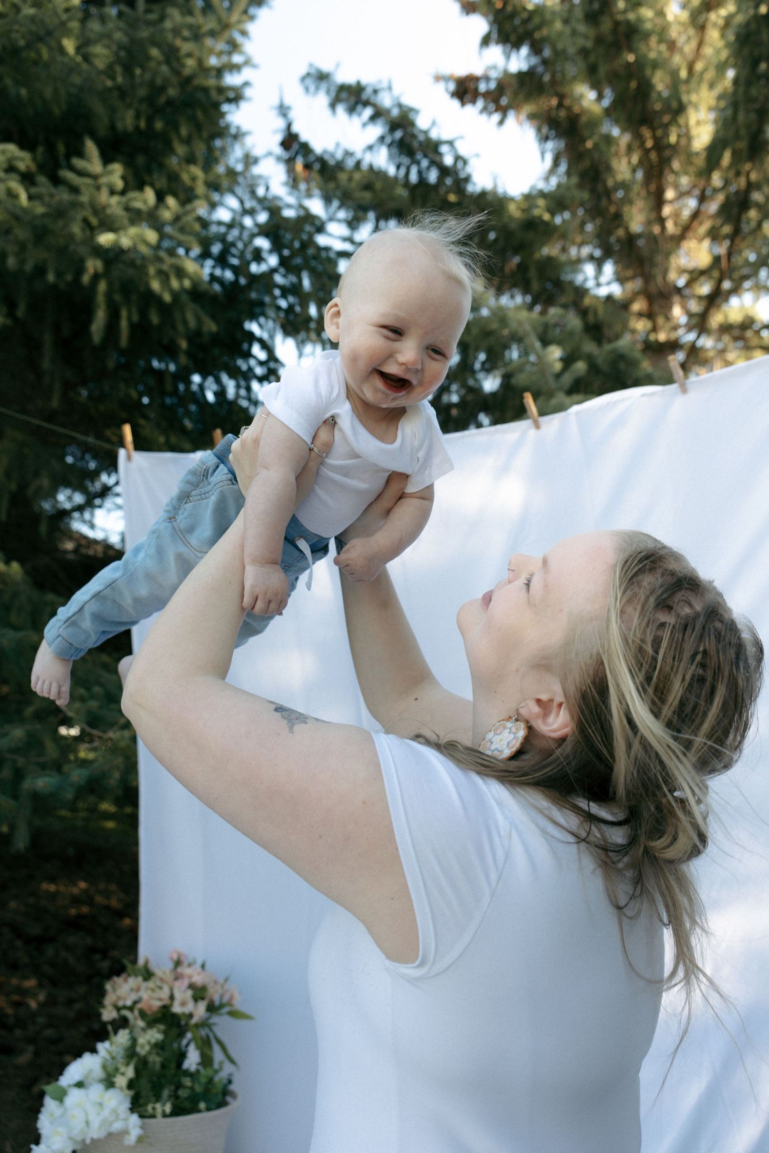 mom throwing baby up as he giggles for mom and me session