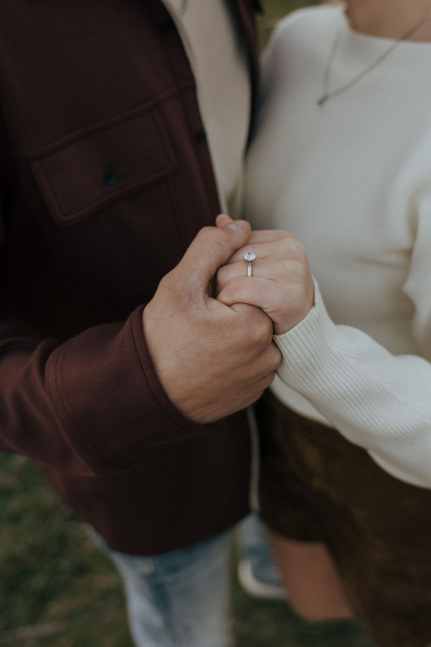 Intimate close-up of hands touching against a dark background.