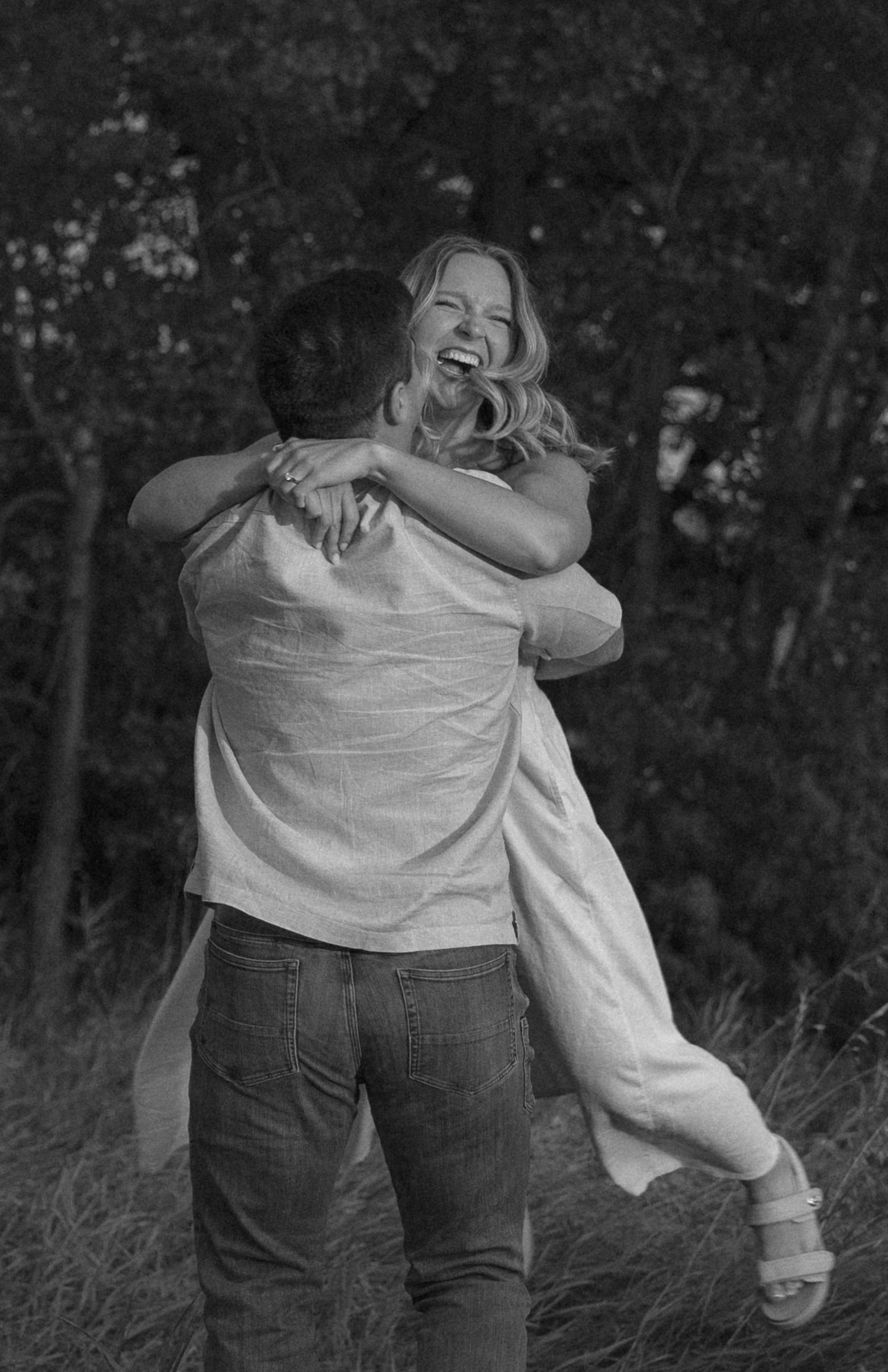 A black and white photo captures two people sharing an intimate dance moment outdoors.