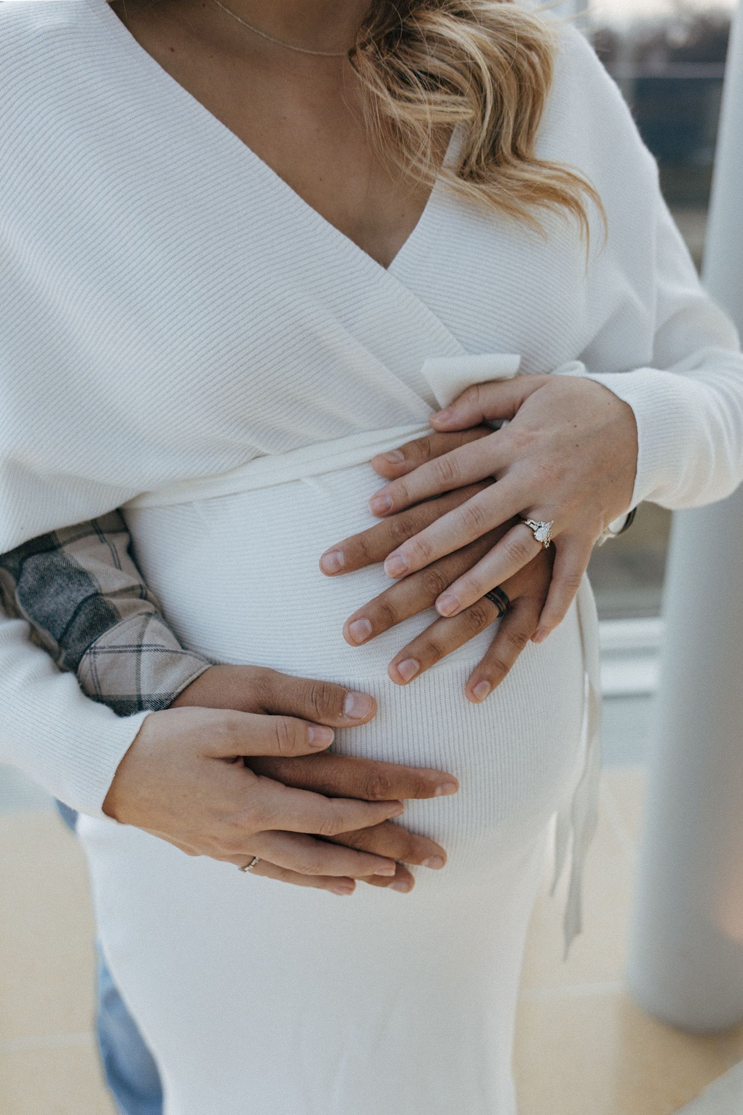 couple embracing holding baby bump for maternity session