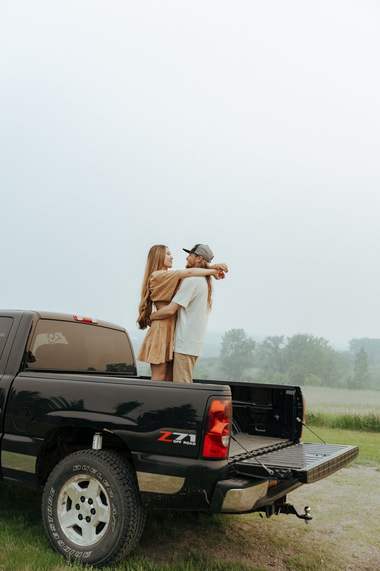 couple dancing in bed of truck for engagement photos