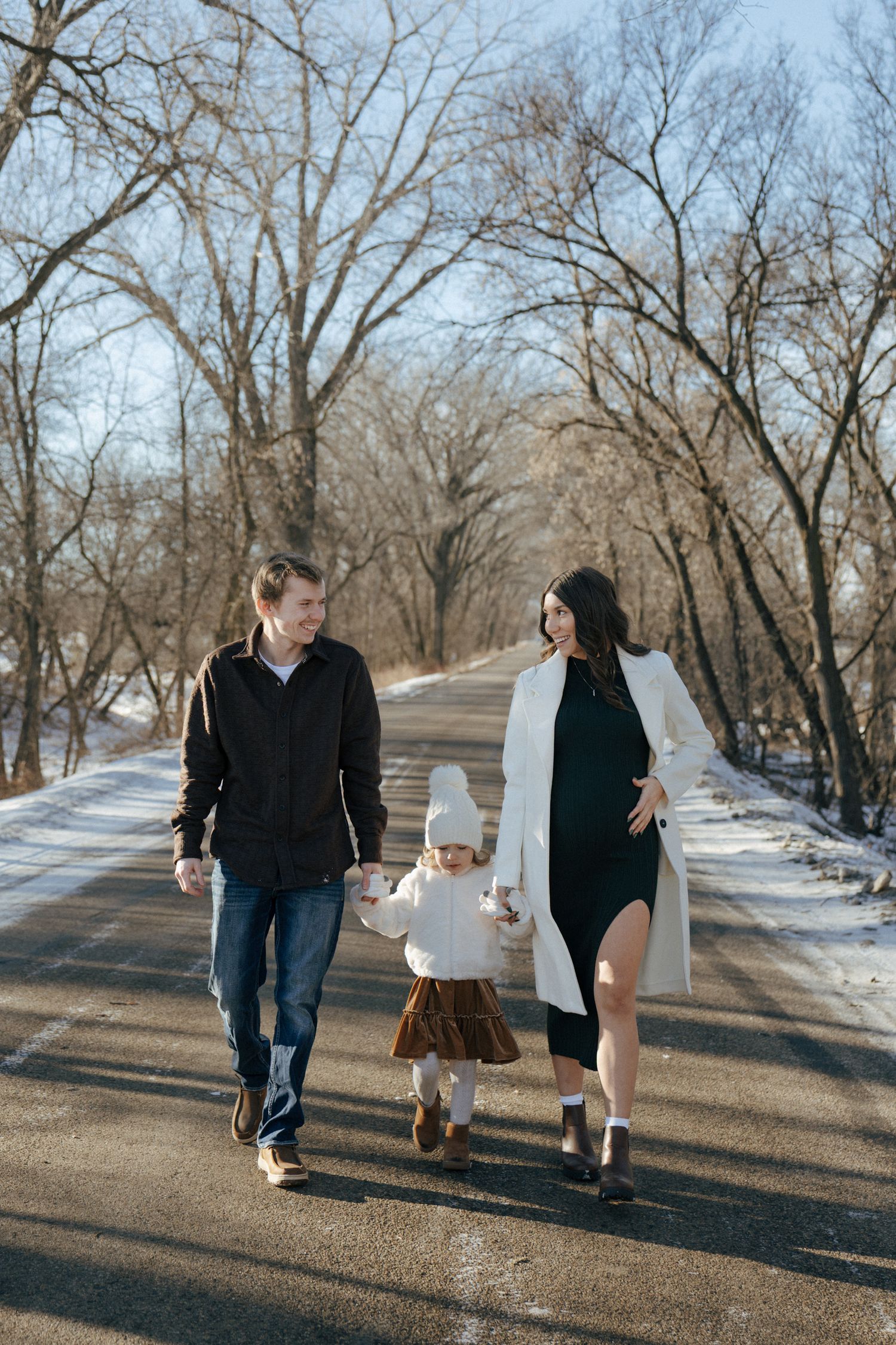 photos of mom and dad with daughter in snowy trees in Bismarck