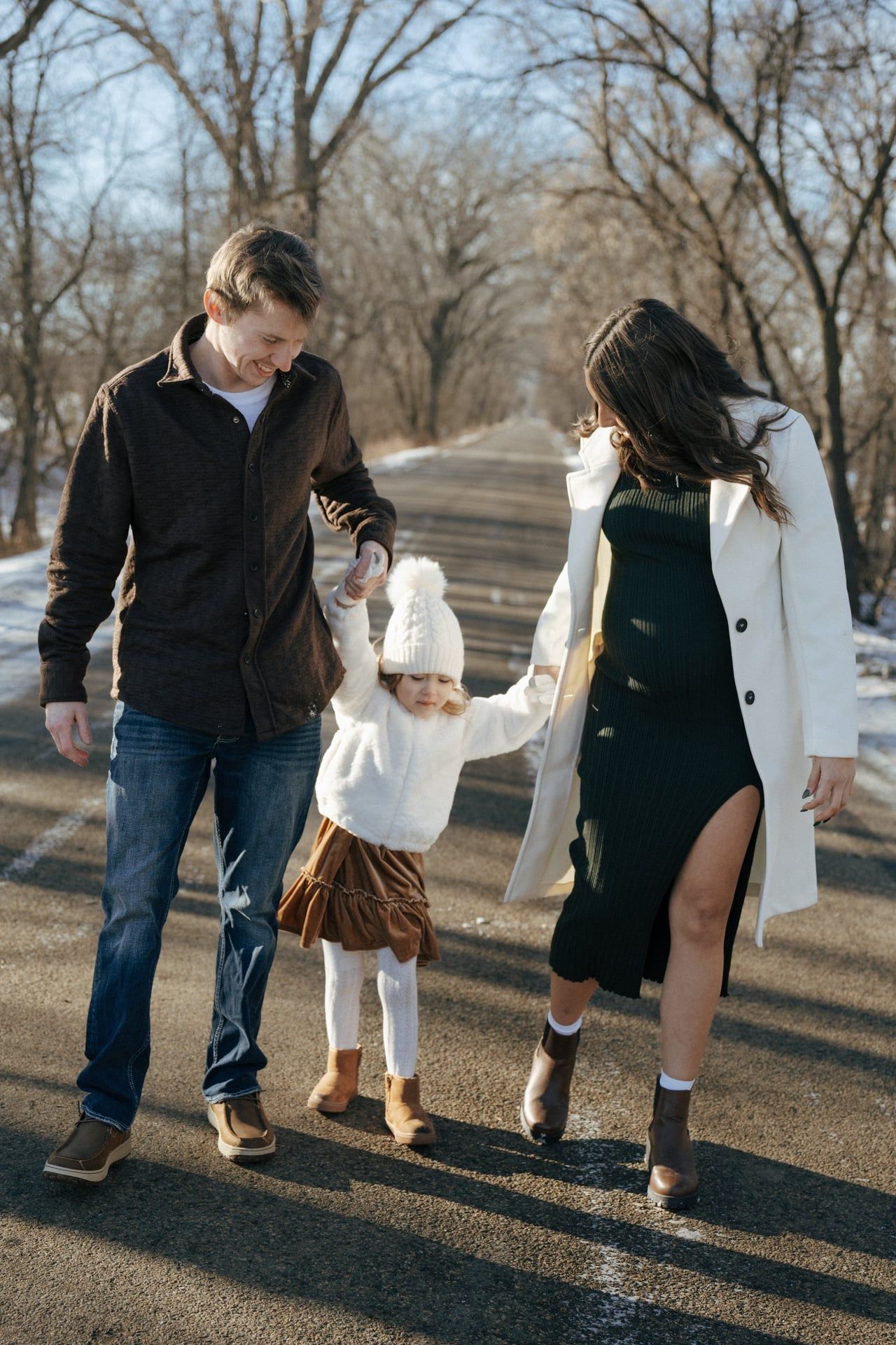 photos of family walking holding hands in snowy trees in Bismarck