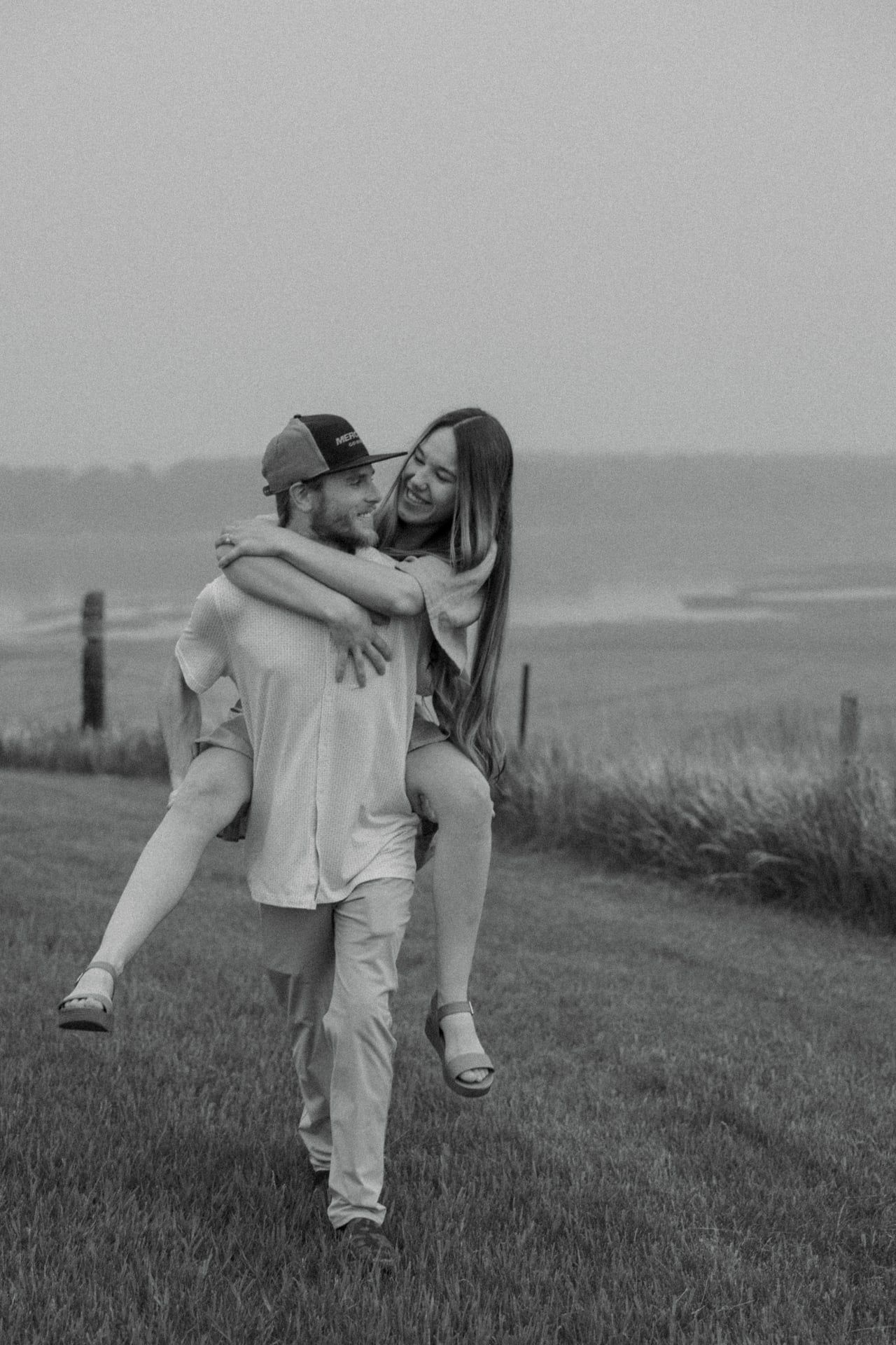 girl having piggy back ride with fiancee for engagement session