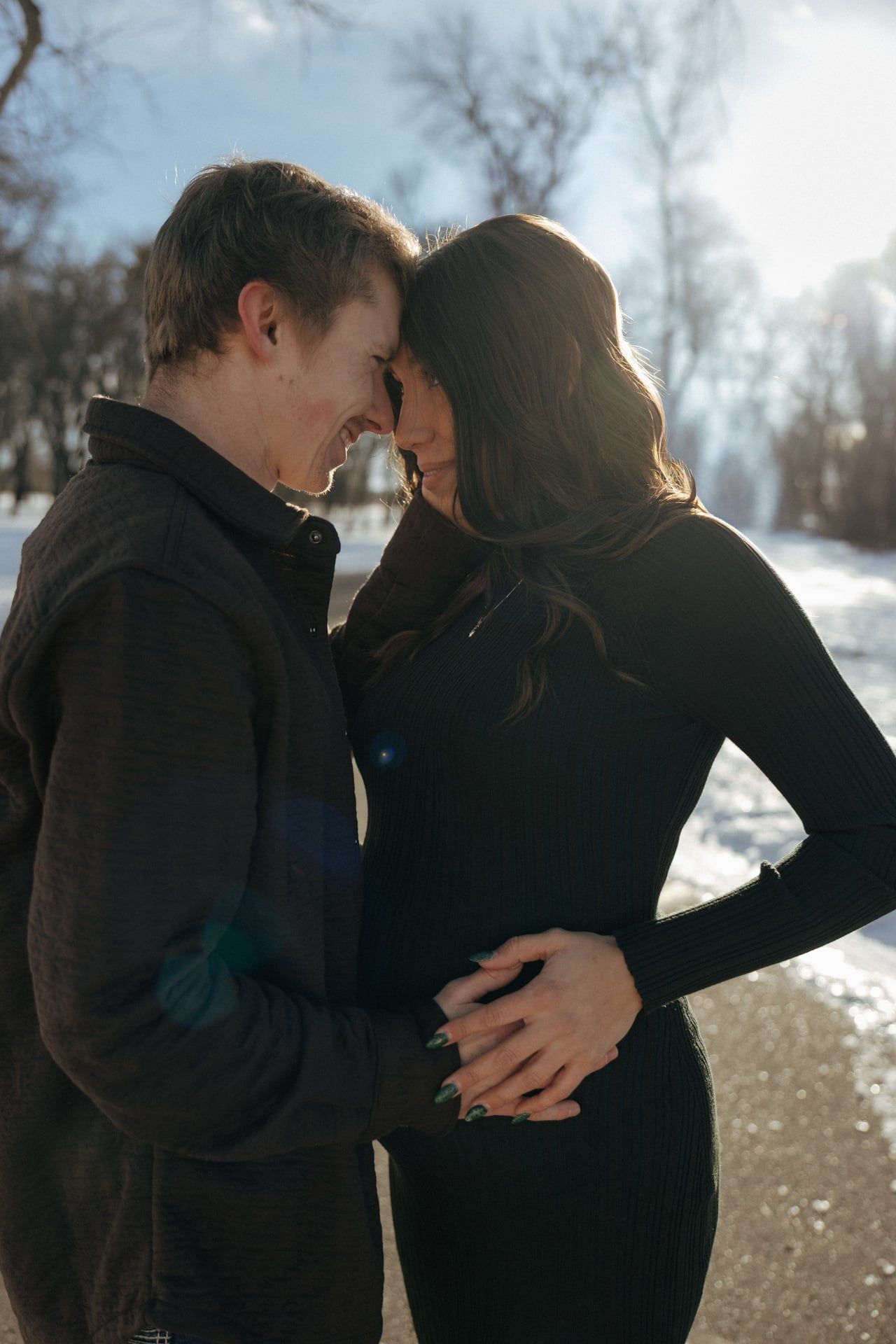 Couple forehead to forehead for intimate moment in winter snowy park