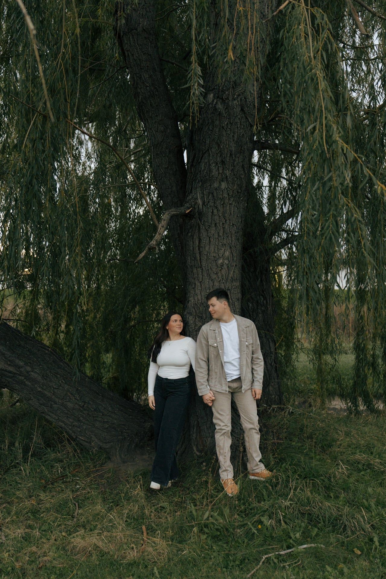 couple standing with weeping willow tree