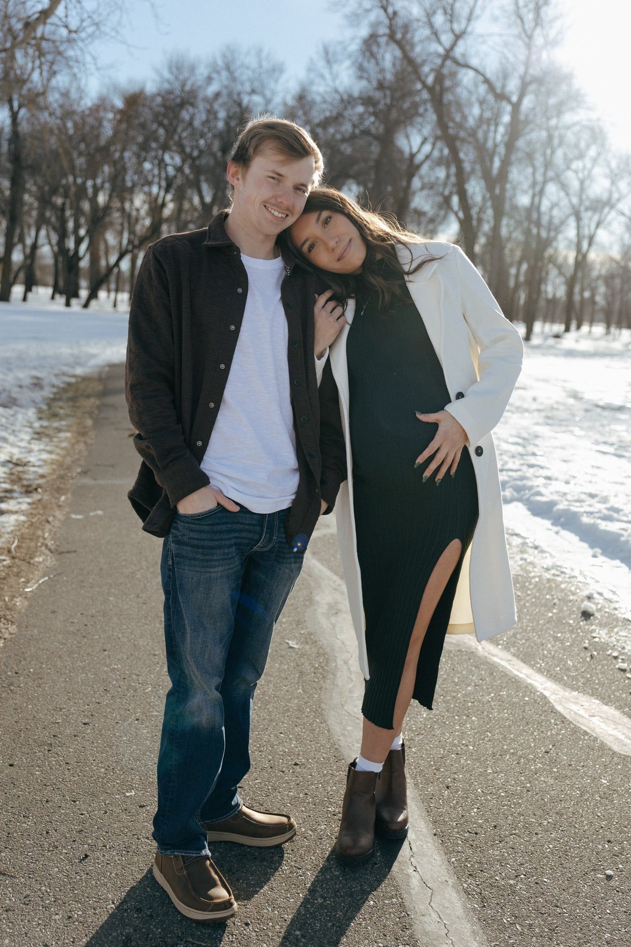 Couple smiling at camera for winter maternity session