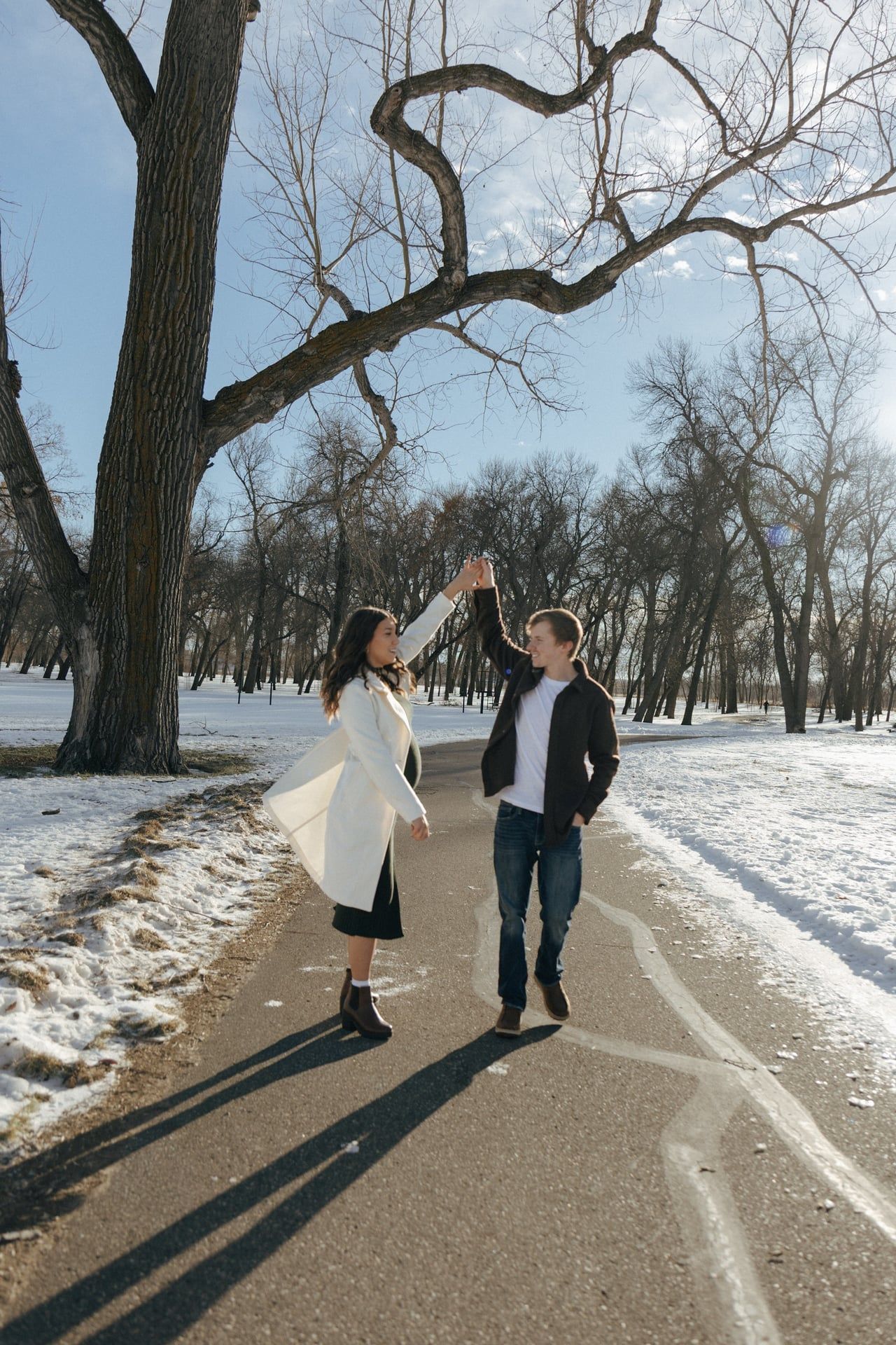 man twirling girl in snowy park in Bismarck