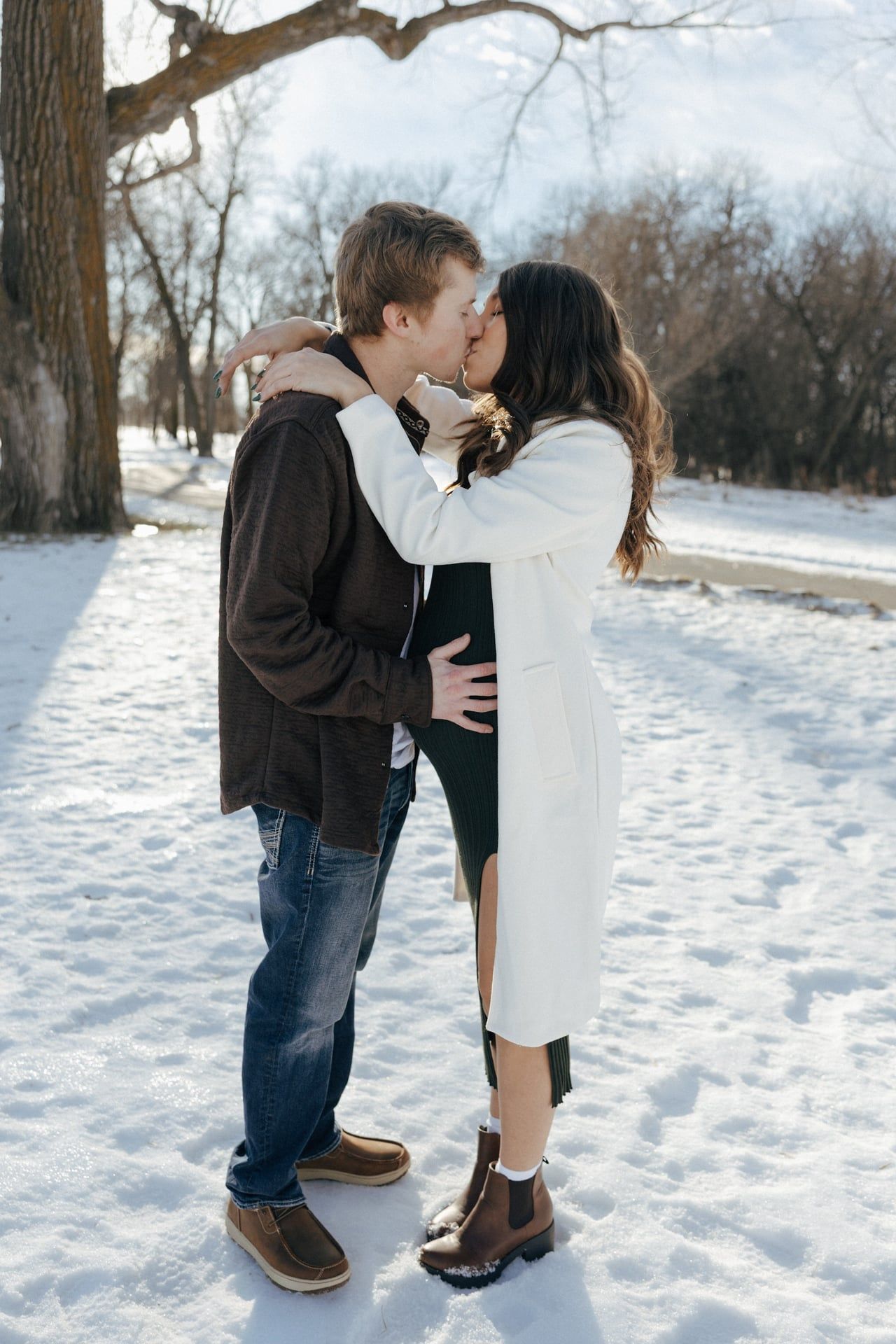Couple kissing in snowy park in Bismarck