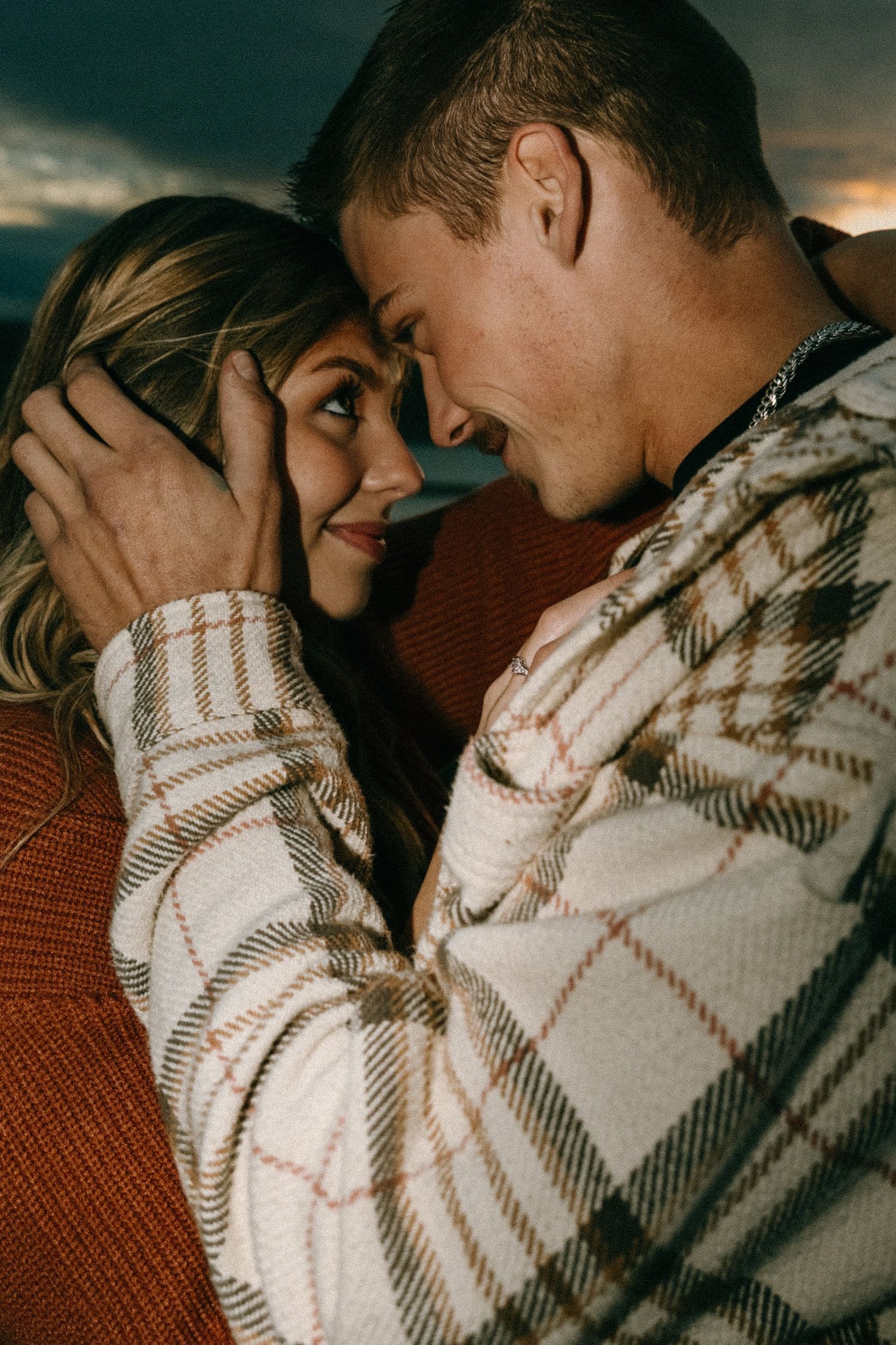 Close-up of a tender moment between a couple wearing cozy winter attire.