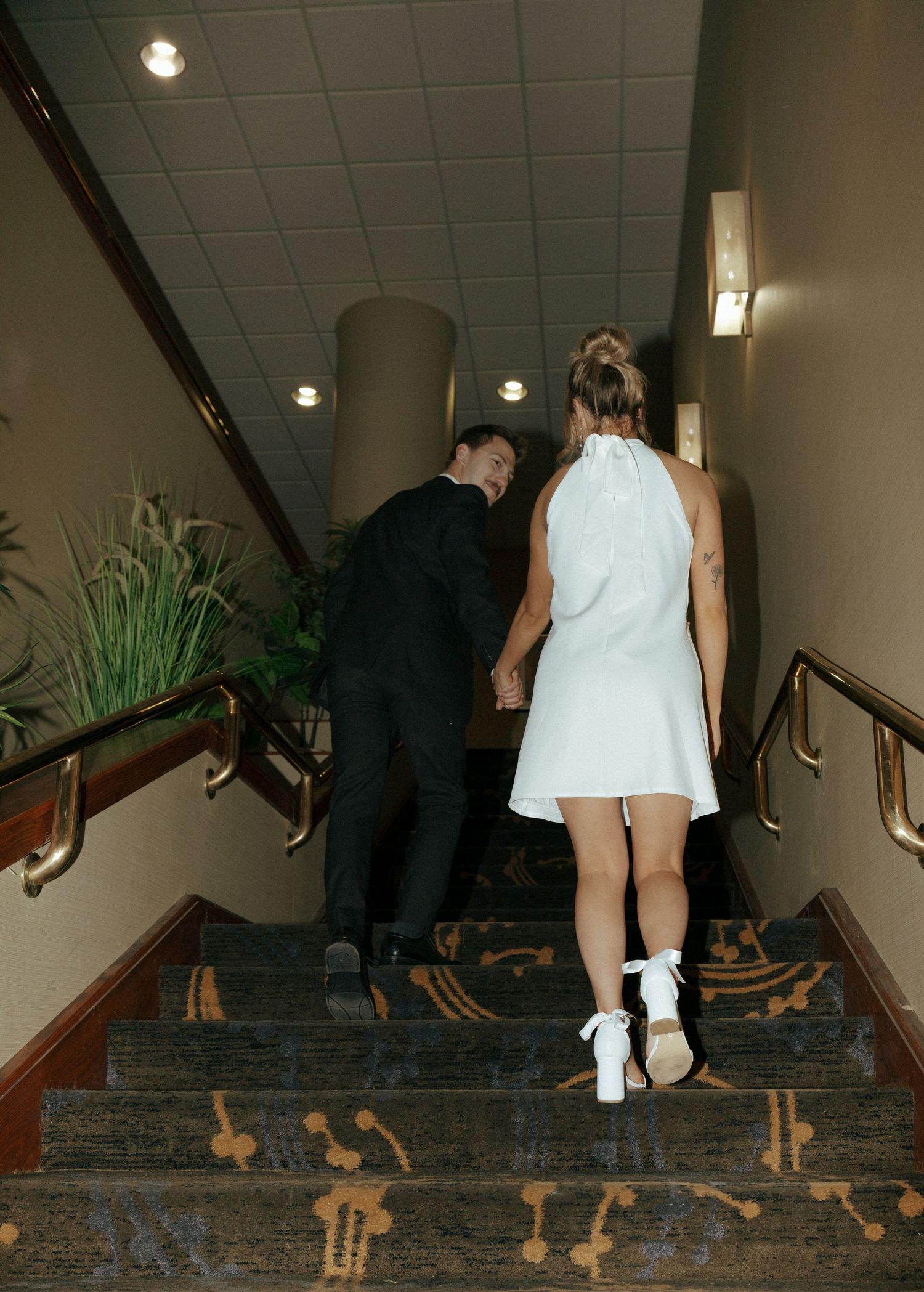 couple walking up hotel stairs for engagement photos