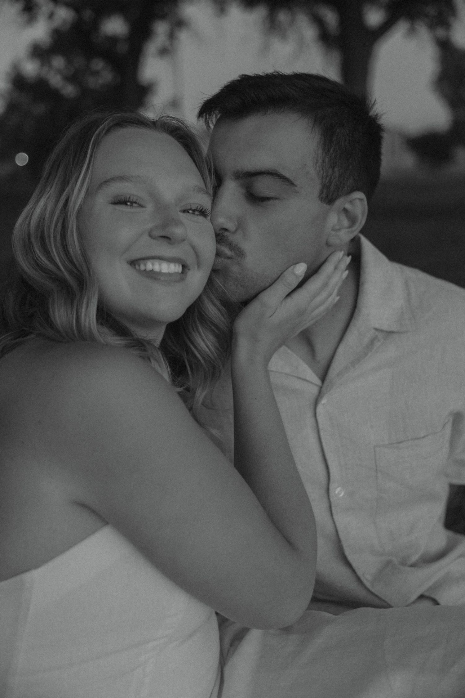 A black and white series showing tender moments between a couple during an outdoor photoshoot.