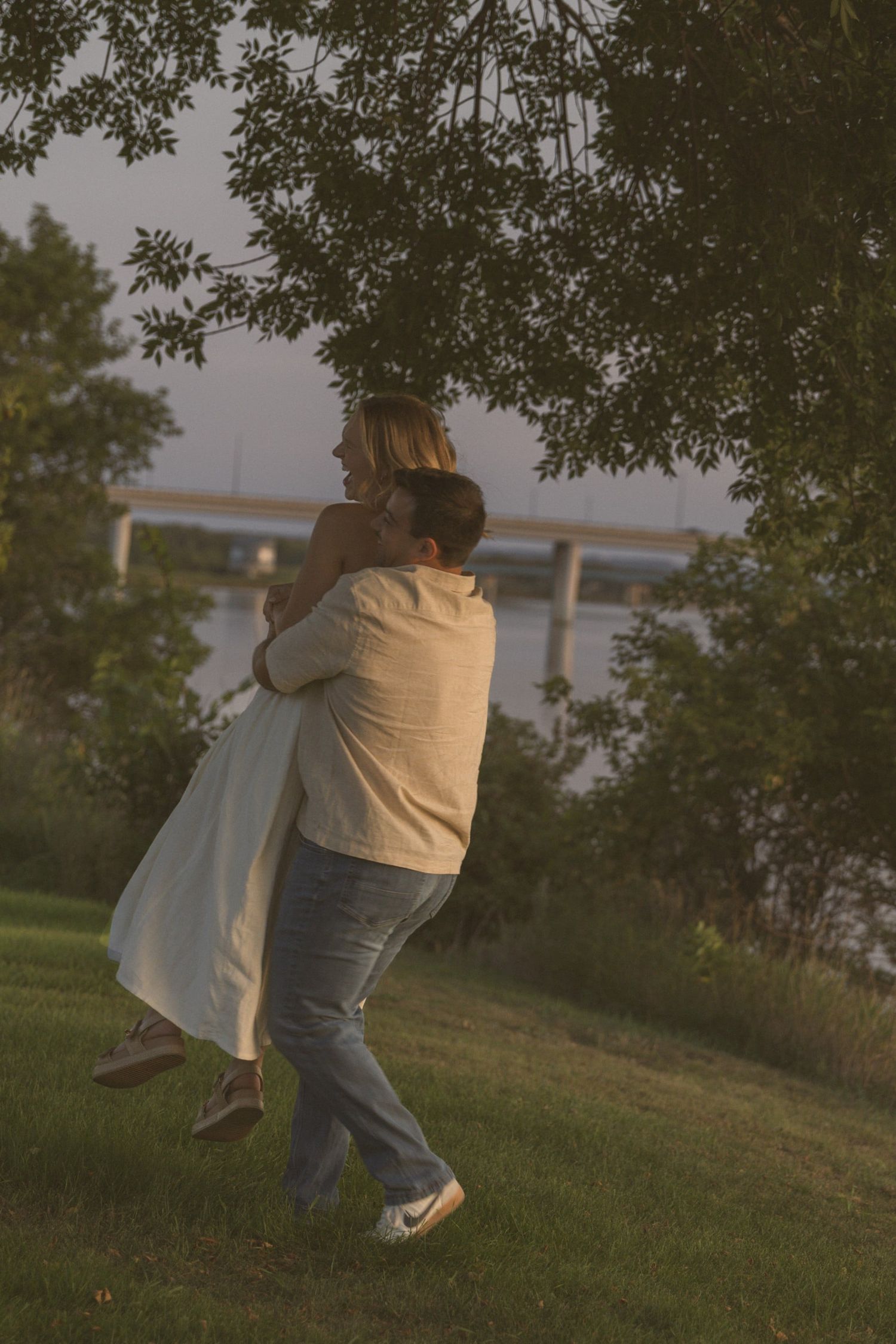 A playful sequence showing a couple spinning and dancing together on a grassy hillside.