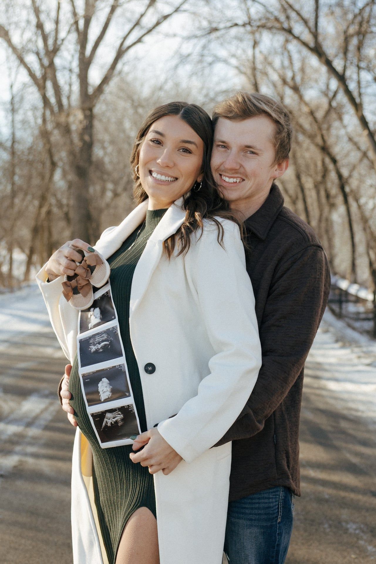 Couple smiling at camera for winter maternity session