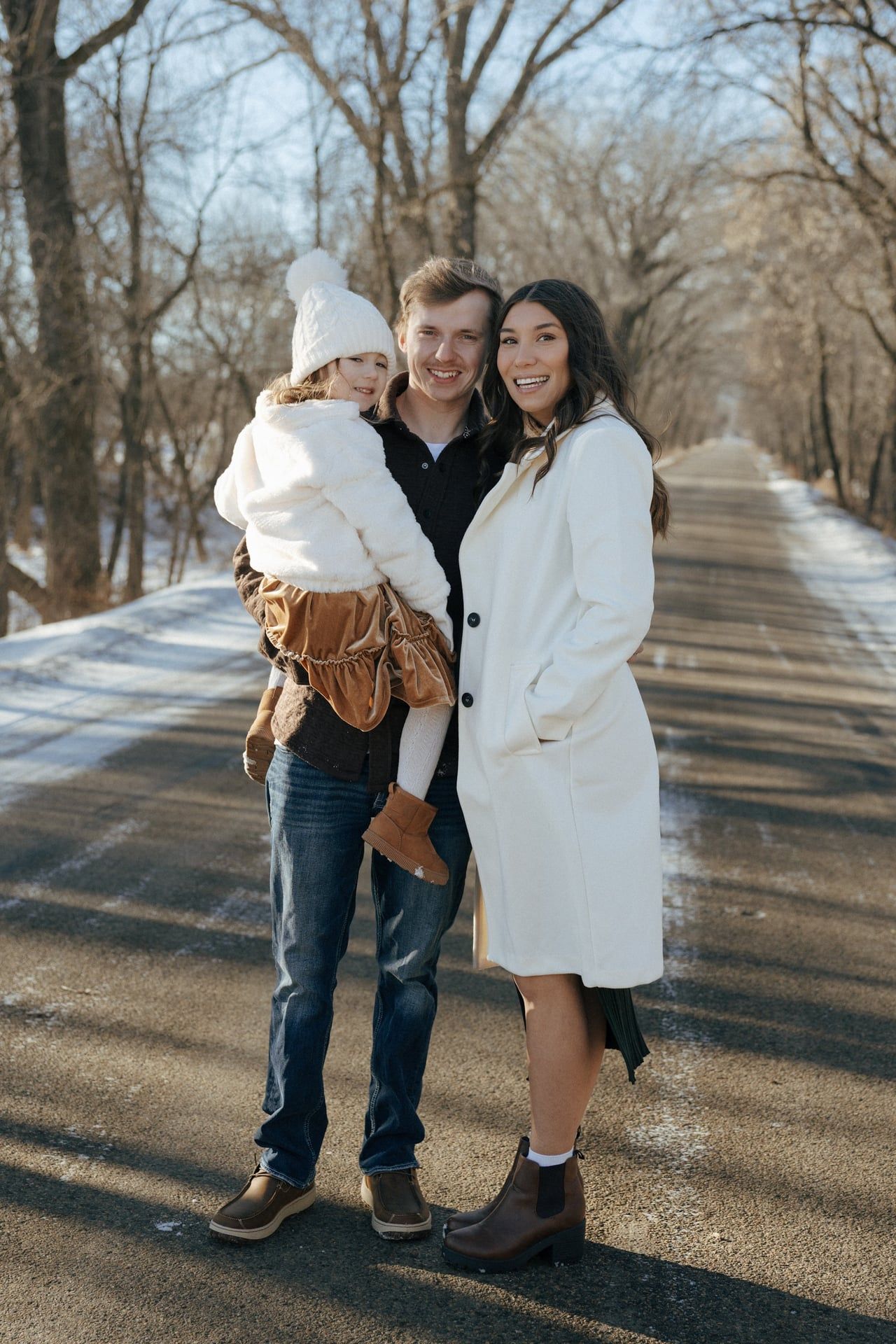 photos of mom and dad with daughter in snowy trees in Bismarck