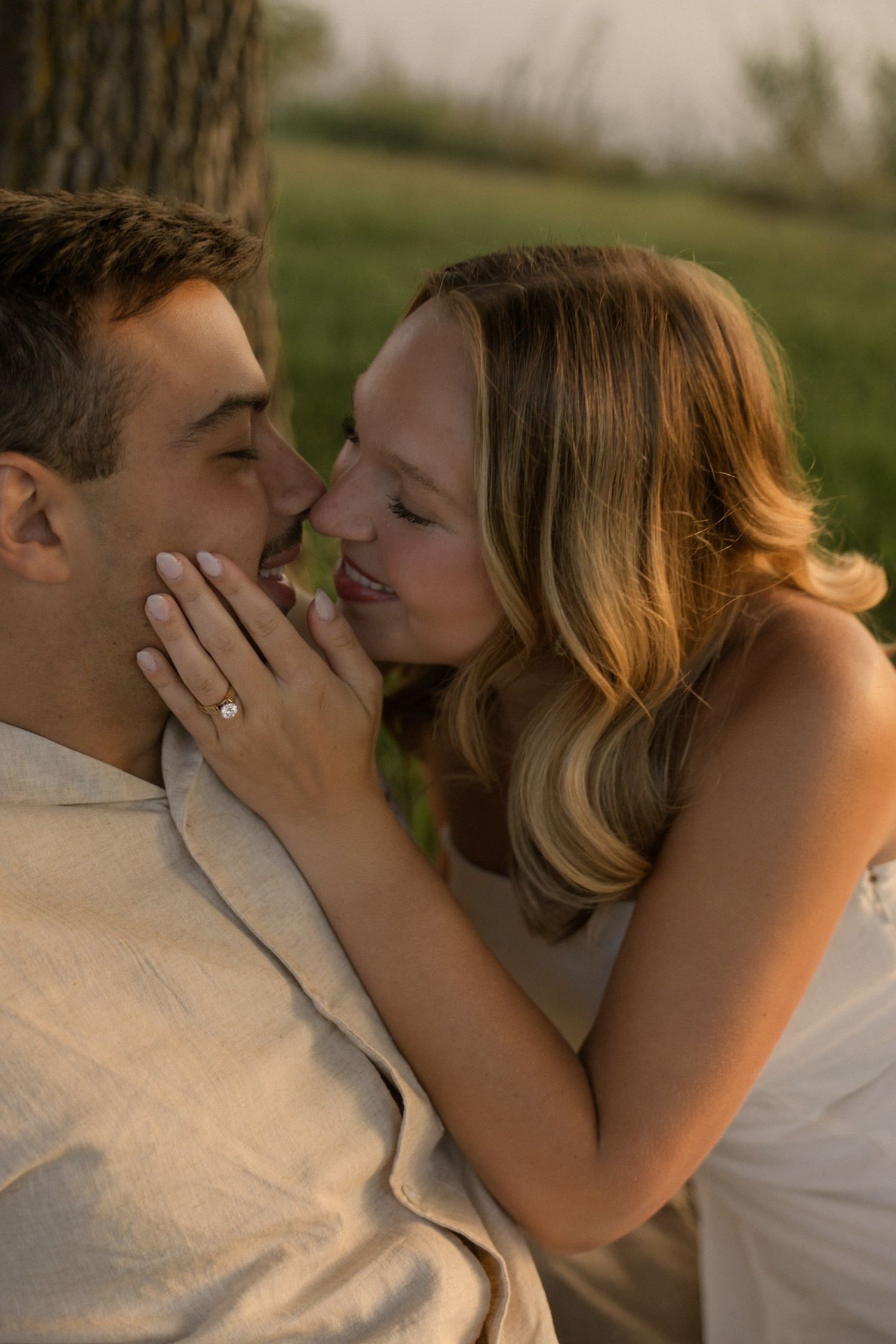A series of romantic close-up shots showing a couple embracing and kissing near a lake.