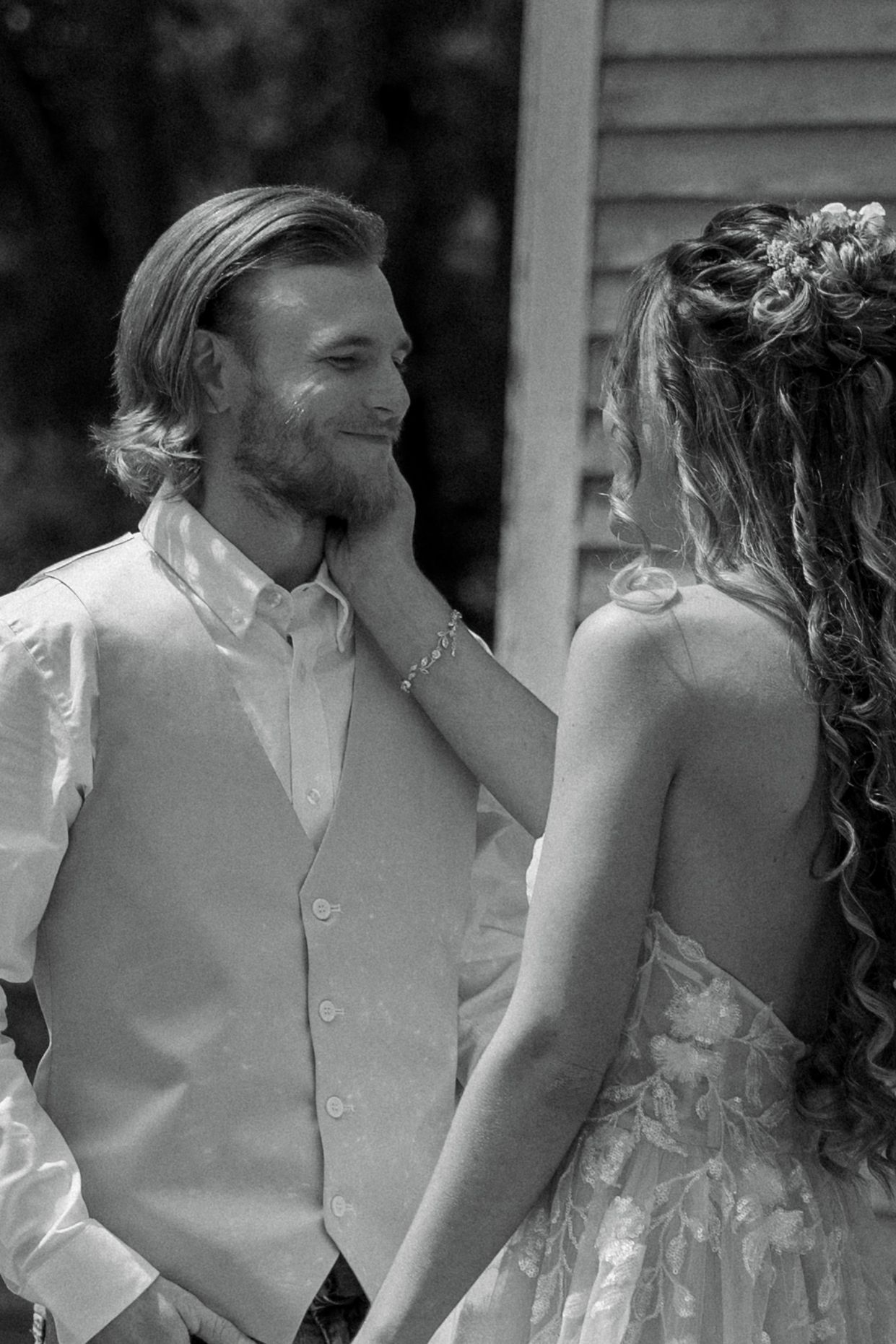 bride holding grooms face during first look