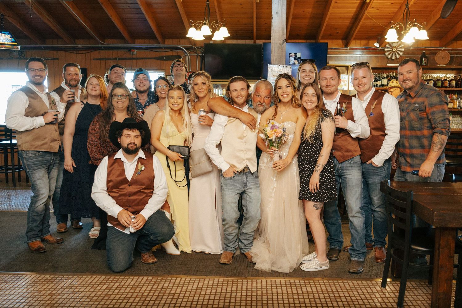 Wedding reception celebration with guests in rustic wooden venue.