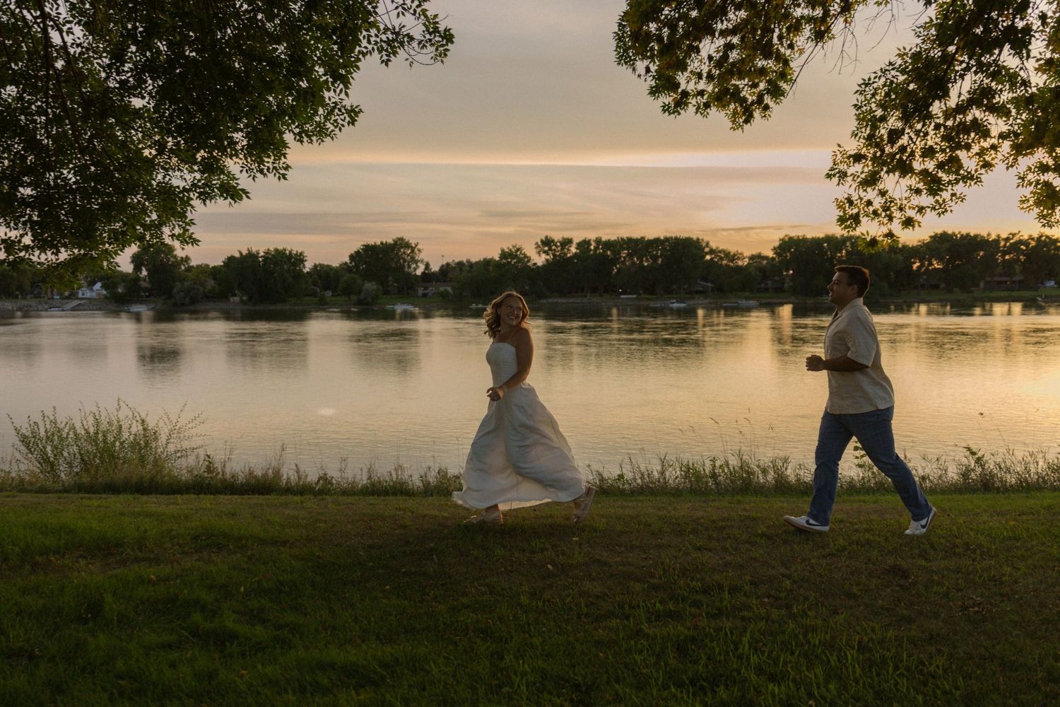 A panoramic view of a couple enjoying a peaceful evening by a serene lake.