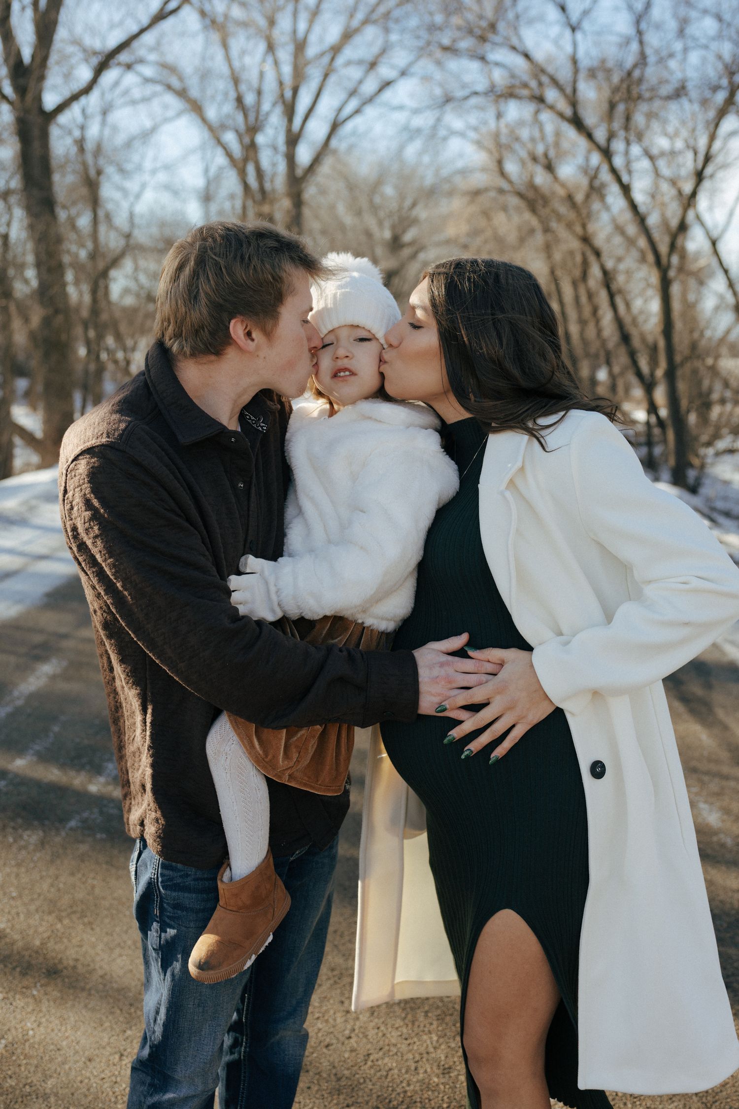 photos of mom and dad with daughter in snowy trees in Bismarck