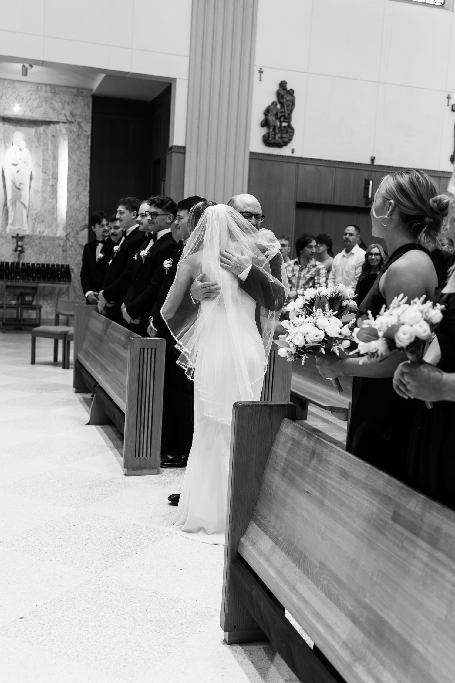 Black and white photograph of a wedding ceremony taking place in a church sanctuary.
