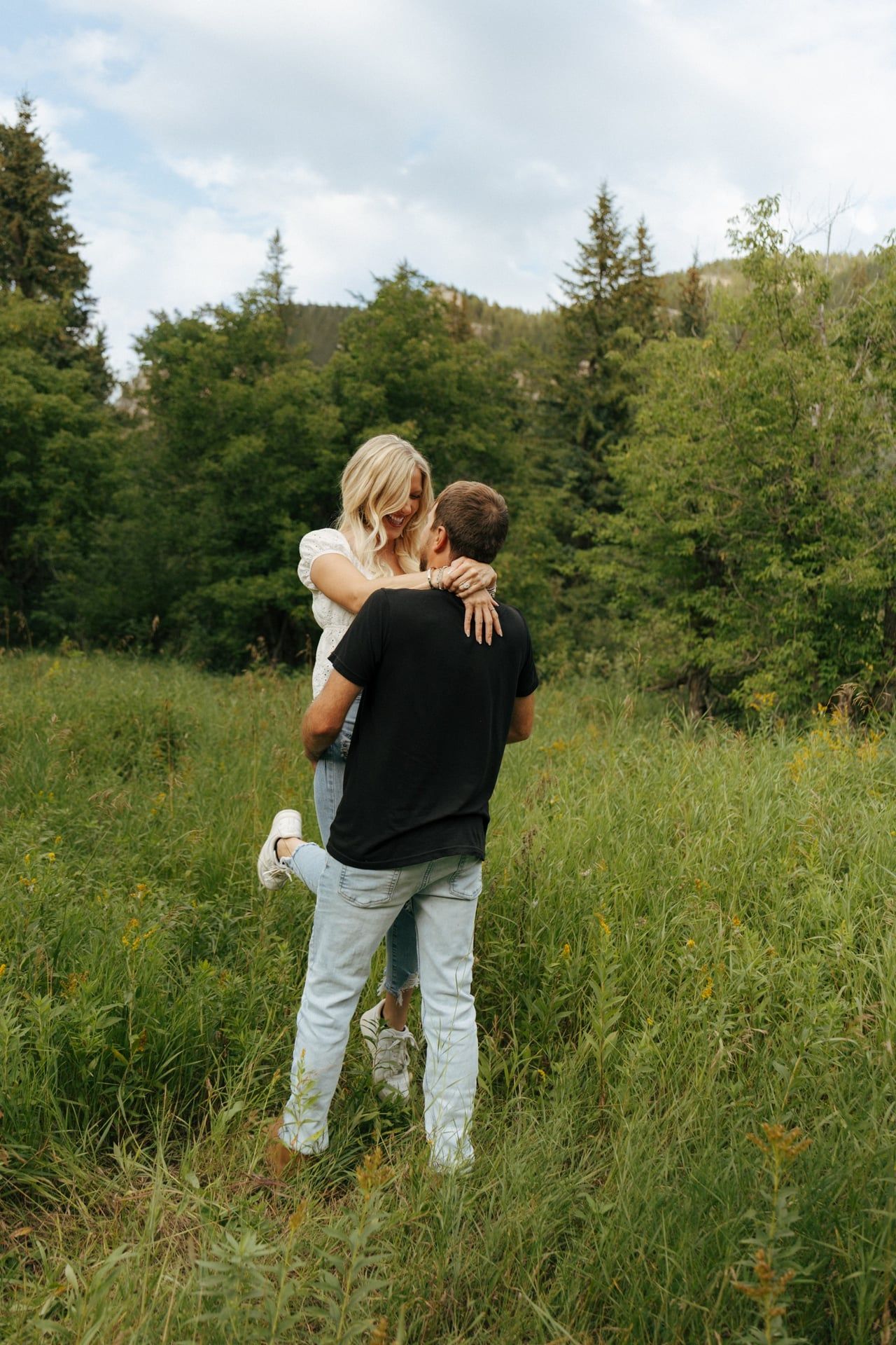 man lifting his fiancee up and spinning her around