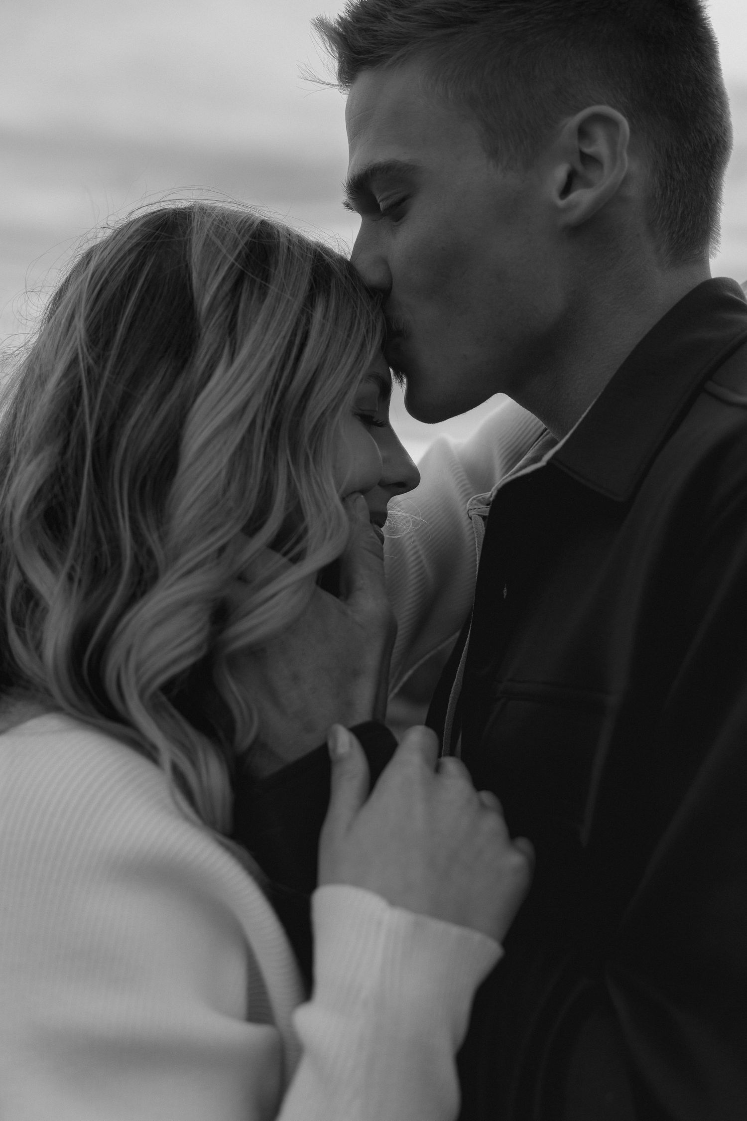 A black and white portrait capturing an intimate moment between a couple.