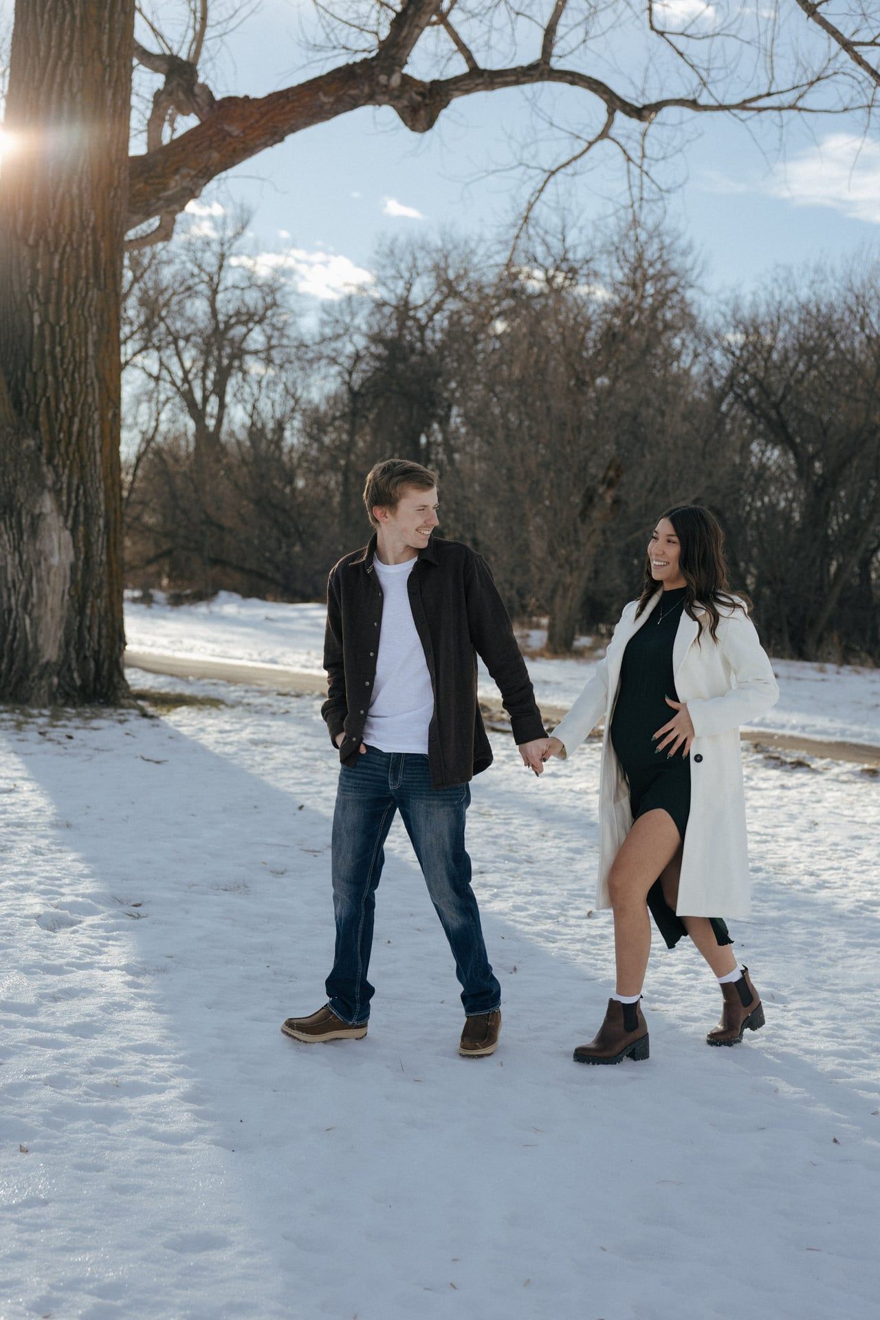 Couple walking holding hands in snowy park in Bismarck