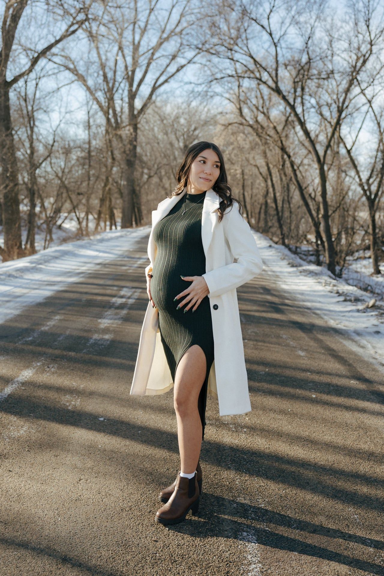 Mom to be in snowy trees in Bismarck with ultrasound photos