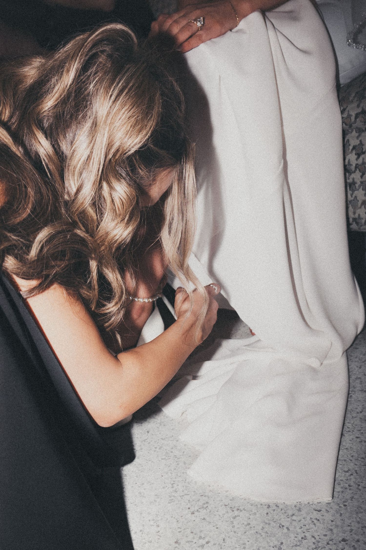 bride getting her shoes on with bridesmaids help