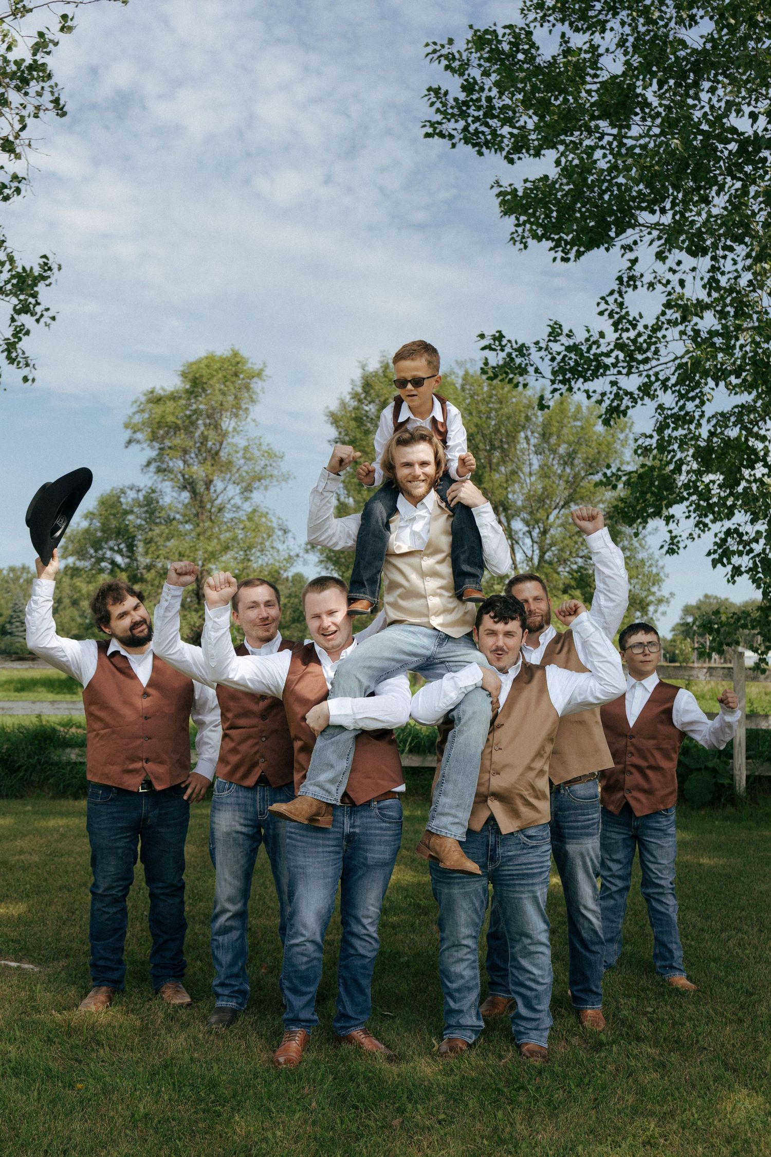the groomsmen holding up the groom and celebrating him on their wedding day