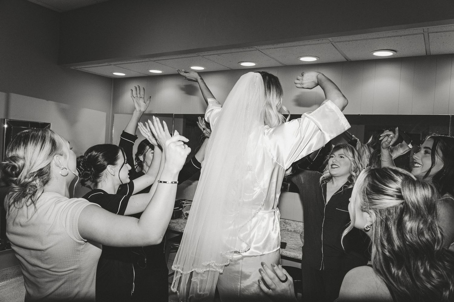 bride getting ready with the girls dancing up on a chair