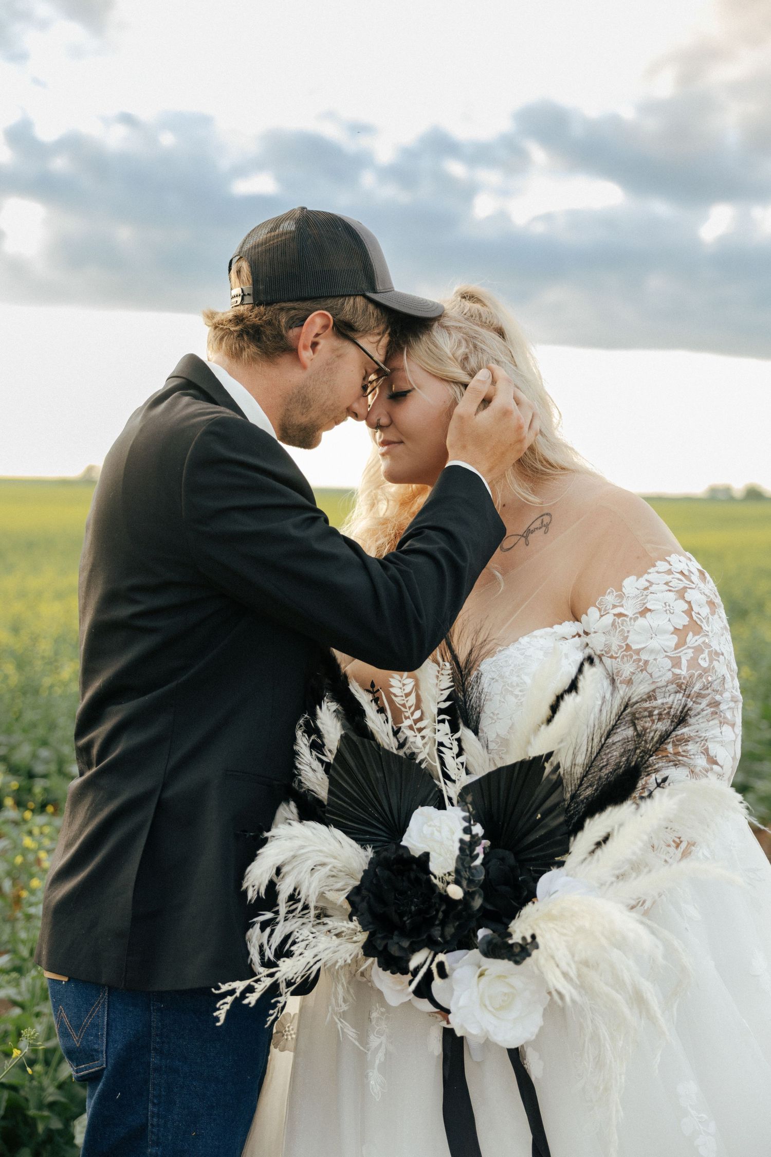 groom holding bride by her cheek and forehead to forehead at sunset