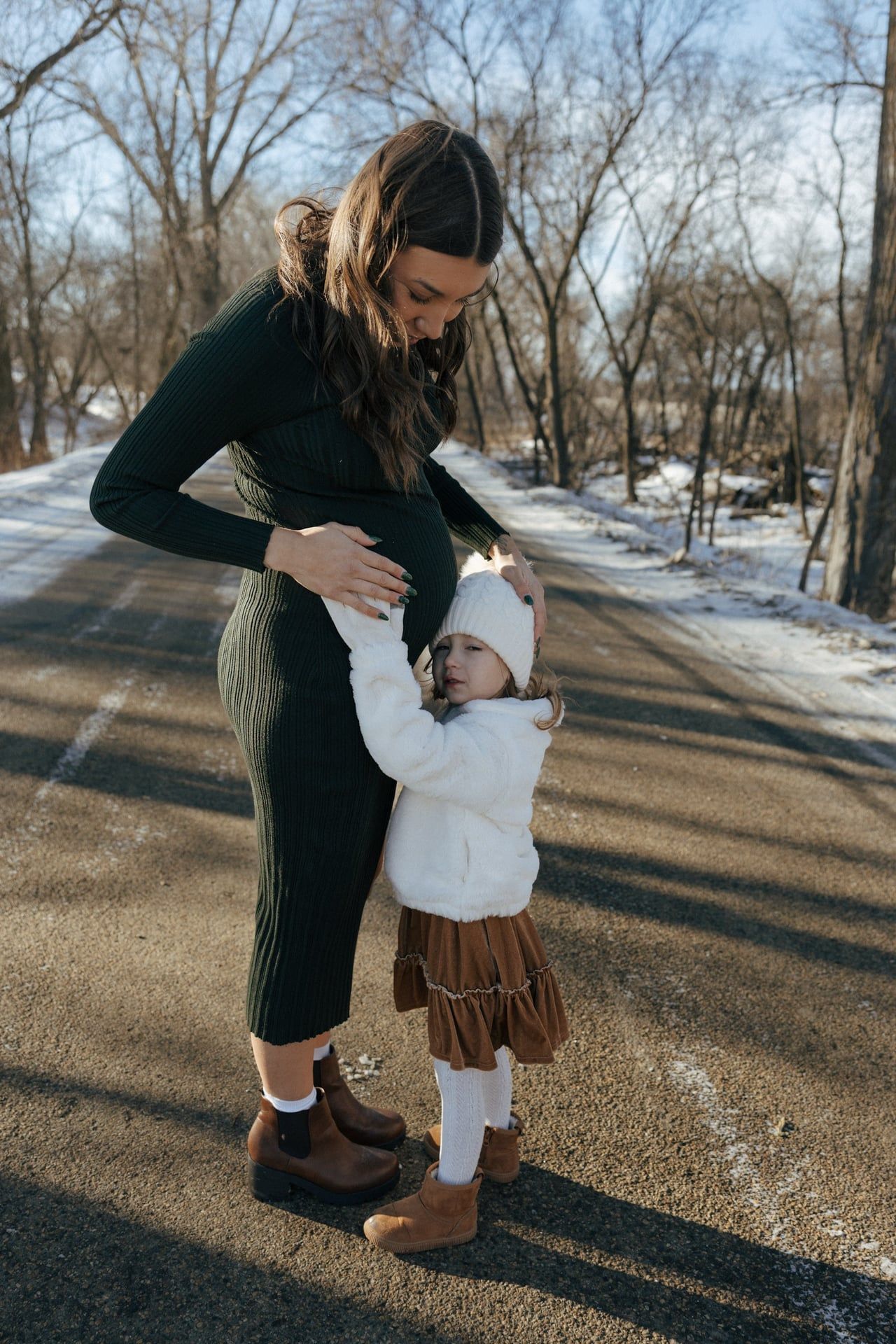 photos of mother to be with daughter in snowy trees in Bismarck