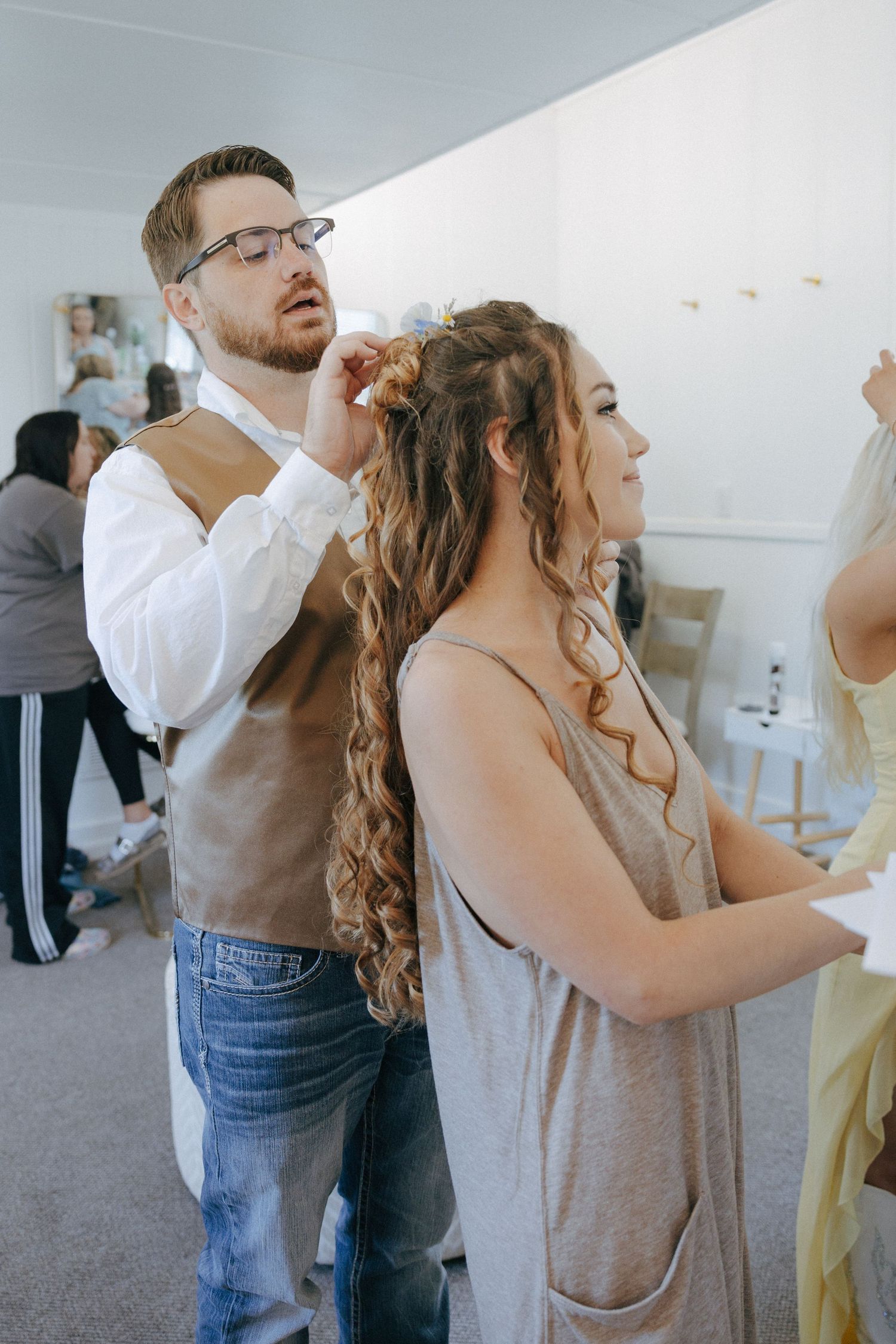 Wedding preparations in a bright indoor space with casual attire.