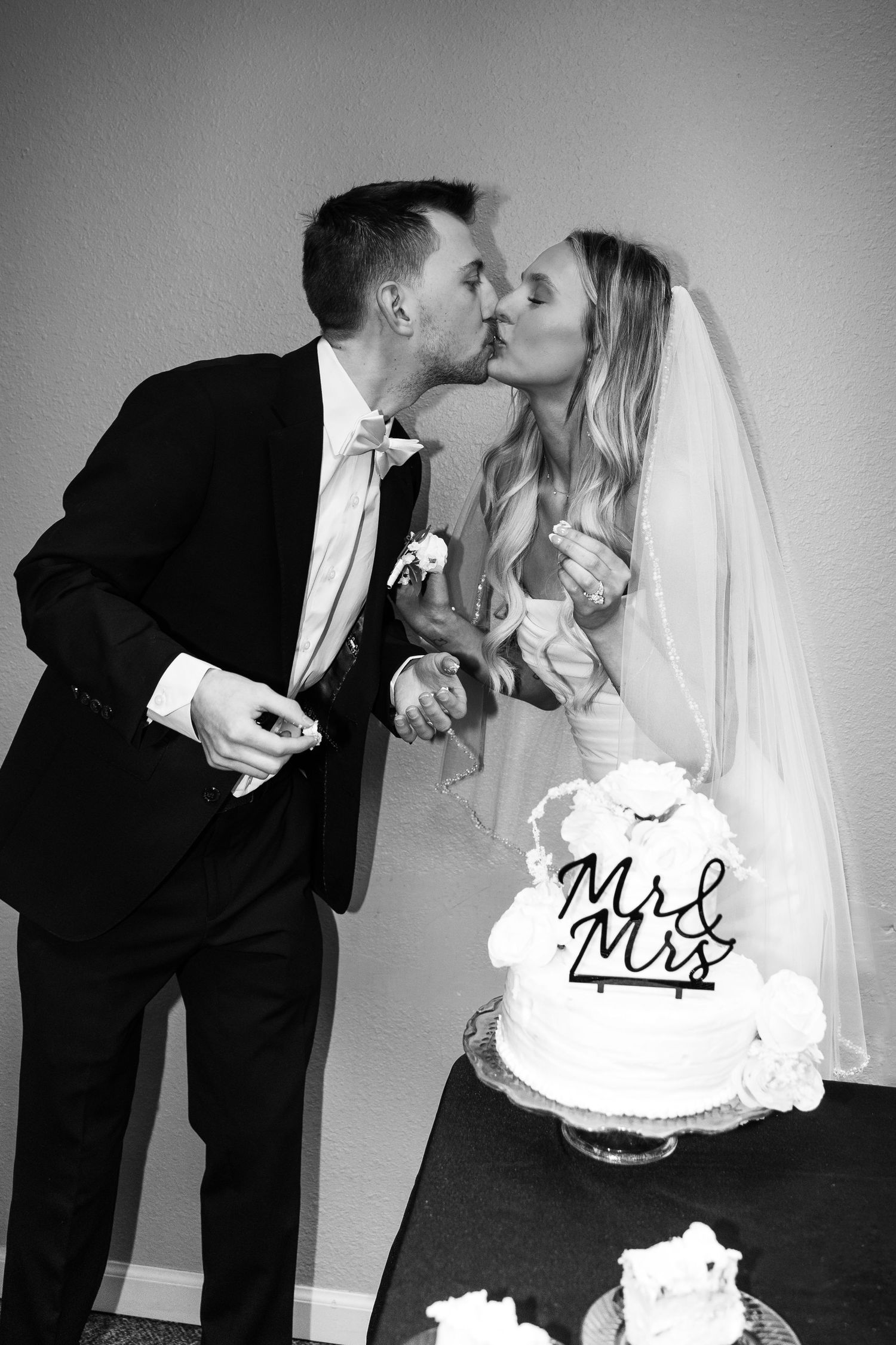bride and groom kissing for cake cutting
