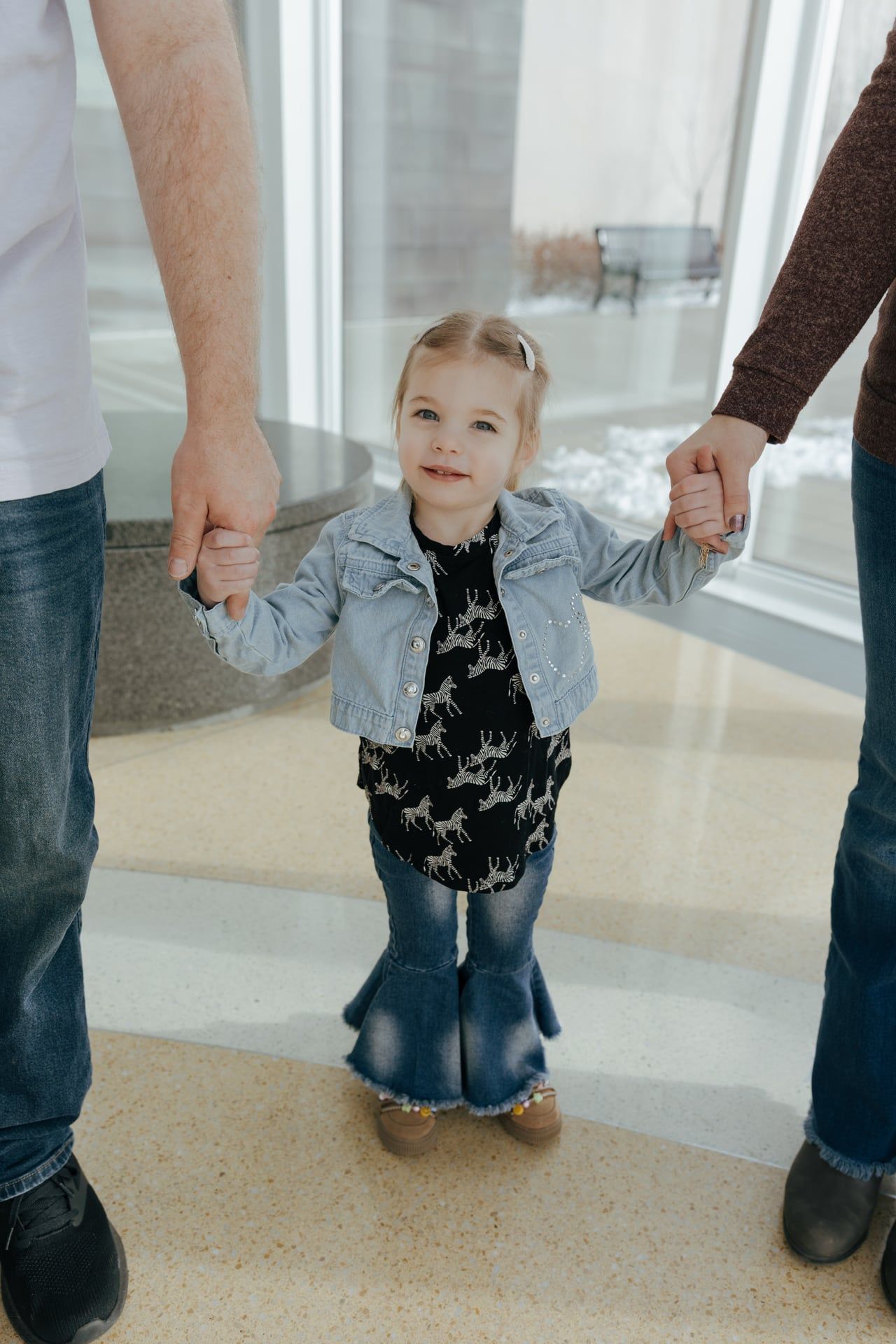 toddler holding mom and dads hands