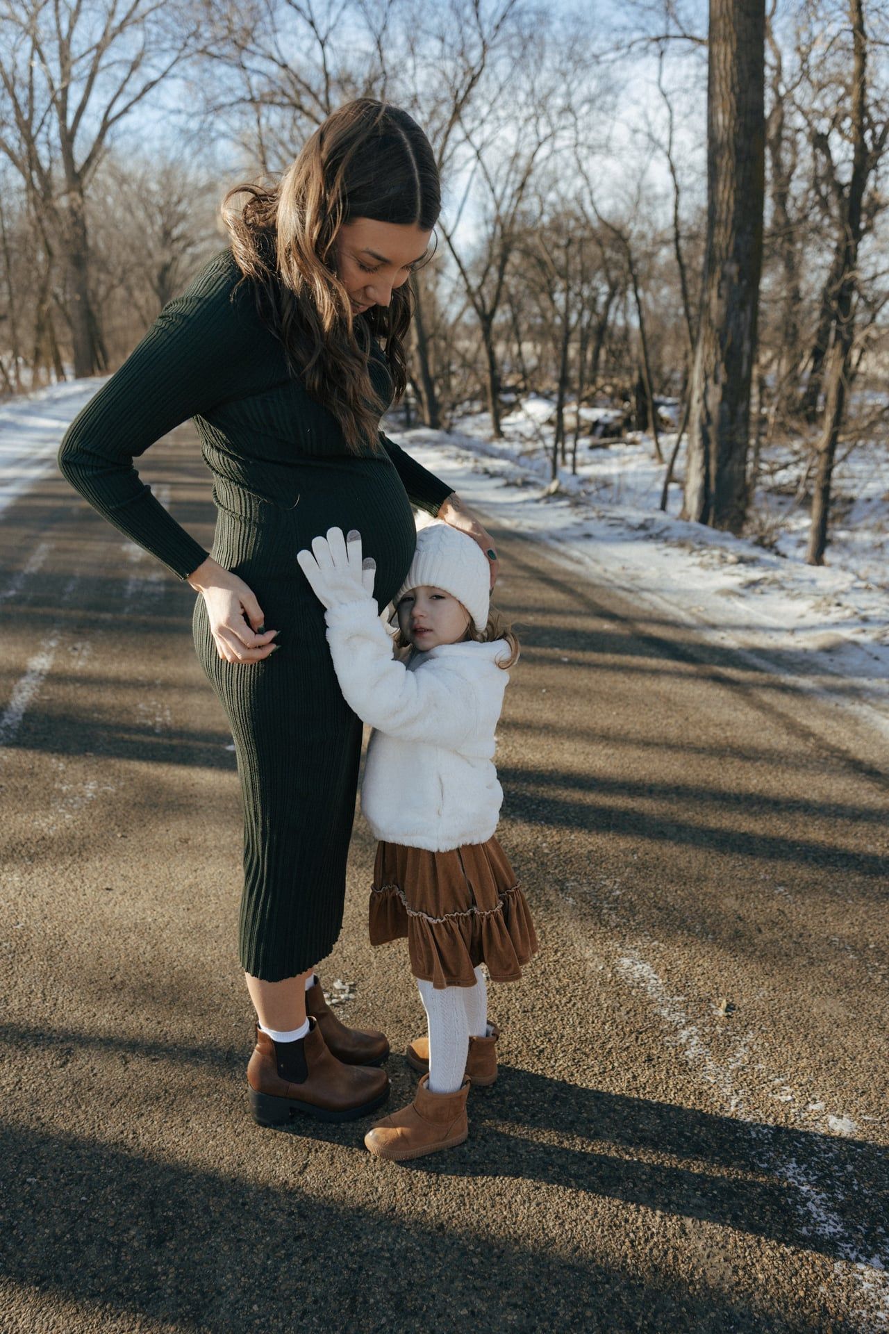photos of mother to be with daughter in snowy trees in Bismarck