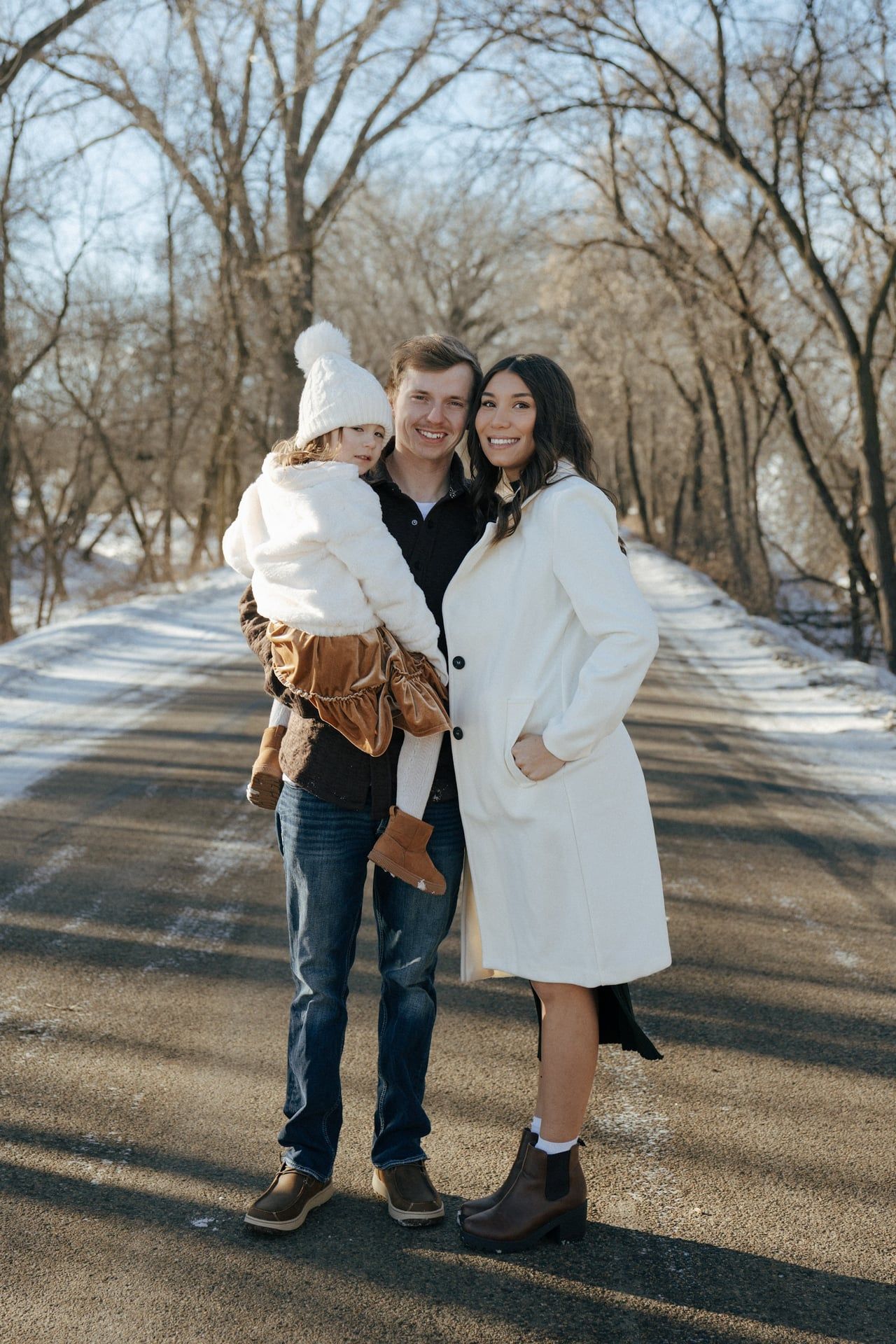 photos of mom and dad with daughter in snowy trees in Bismarck