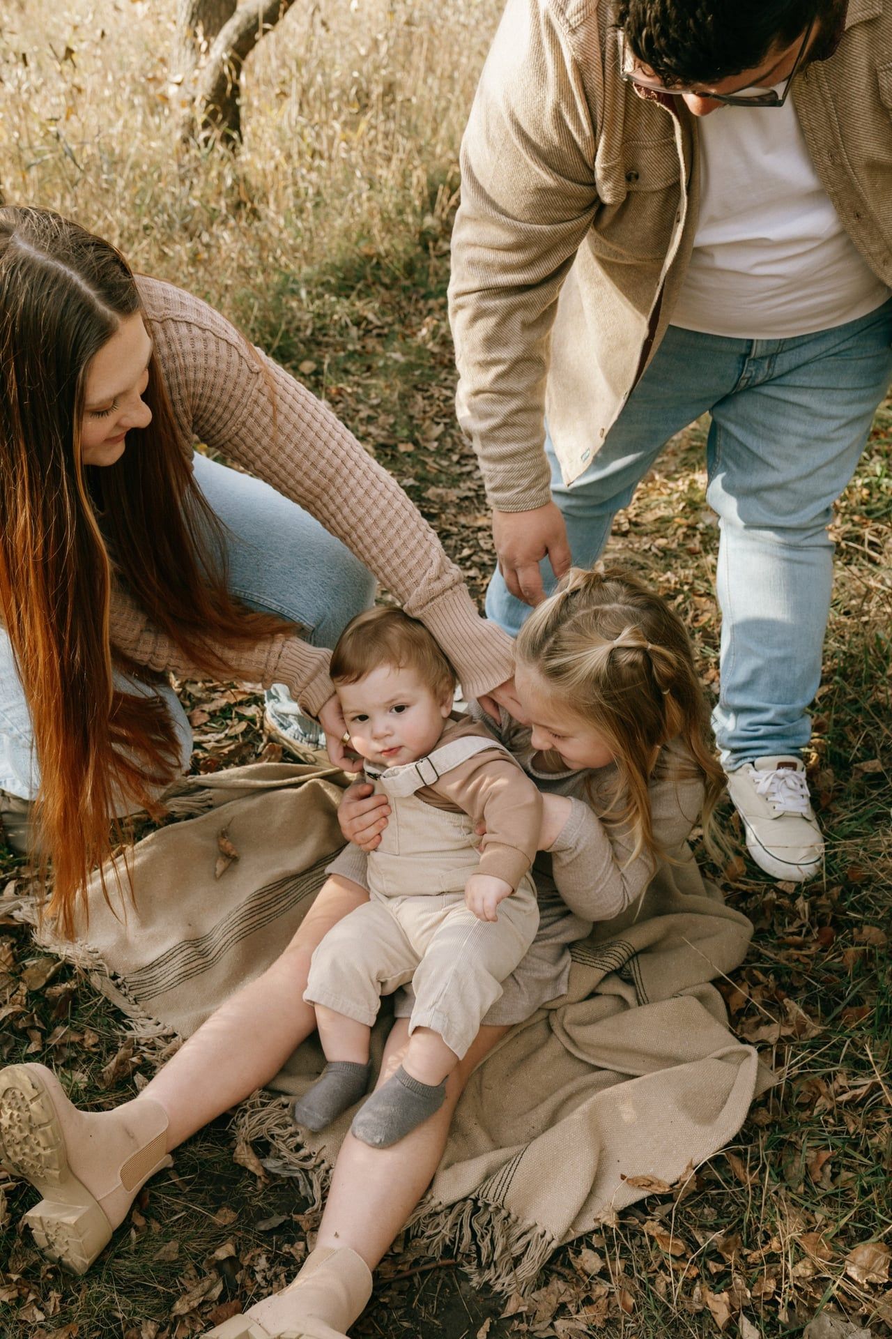 family in park in Bismarck with parents tickling children and the kids laughing